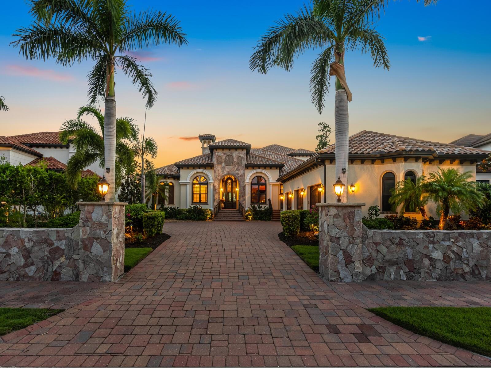 Welcome to the market for the first time, this elegant custom built estate located in the exclusive private gated community of  Blackburn Ridge, situated on Blackburn Bay and the Intracoastal Waterway which is near the communities of Osprey, Laurel, Nokomis, and Casey Key. 
Welcoming you at the entry to this estate, you will find a 68’ stone wall, which each piece was hand cut to give a dry fit appearance.  Enter through the hand crafted custom entryway door and immediately take in the view from the beautiful water beyond.  This estate boasts 4 full bedrooms and 5 full baths, with the entire second story designed for entertainment with its theater room seating and built in bar, complete with dishwasher, ice maker and wine cooler.  There is also a full bath and murphy bed, which this space could easily serve as a second master suite is so desired. From the second floor, you can enjoy the natural beauty of the water views from the full-length balcony.  The chef’s kitchen will delight all cooking professionals and enthusiasts with its expansive island and Thermador appliances.  The custom wine cellar with its vineyard murals will make you think you are in Tuscany! Host your guests in the stunning dining room as you enjoy watching the sunset.  The living room creates a fabulous gathering space with its custom fireplace and volume ceilings.  The immense master suite provides waterfront views, separate sitting area, and his and hers custom walk-in closets.  The master bath includes soaking tub, oversized shower, and private commode. Jack and Jill bedrooms are ensuite, as well as the remaining bedroom.  Make endless memories with family and friends while entertaining on the patio, with full kitchen and saltwater pool.  The 90’ no profile dock with hydraulic remote-control lift allows you access to the intracoastal waterway via kayak or paddle board.  If you are a boater, there is a full-service Marina just minutes away. To complete this estate is an oversized 3 car garage, with elevated ceilings for all your storage needs, whole house generator, impact windows and doors, 2 a/c’s with dehumidifiers, water and electric at dock, solar outdoor lighting, fenced in dog run, and mini split in wine cellar.  Just a short drive to the top Gulf beaches, shopping, and restaurants, this is the perfect place to live the luxurious waterfront lifestyle that the West Coast of Florida has to offer.