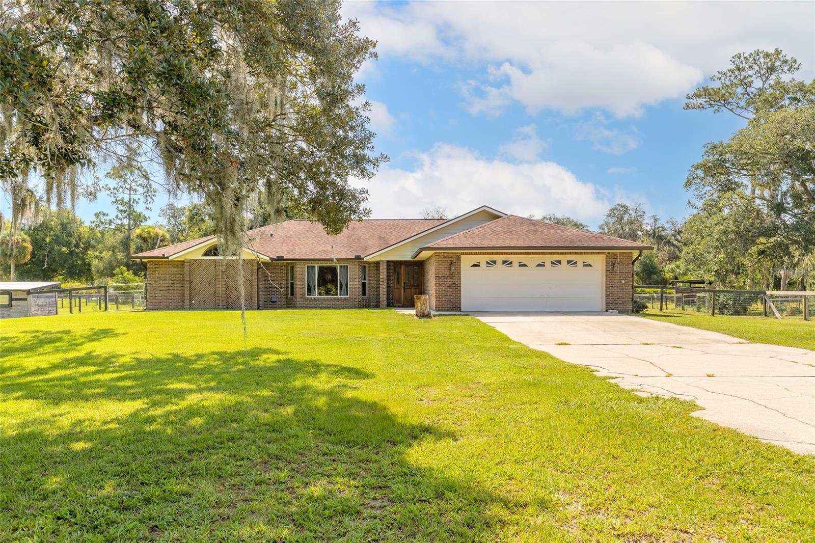 Welcome to paradise, where space, comfort and country living come together! Situated on a property that welcomes your RV, recreational vehicles, and even farm animals, this home offers the freedom you've been looking for! Inside you will find a spacious split-bedroom floor plan featuring an oversized primary suite with a large walk-in closet and French doors leading to a private enclosed florida room complete with it's own mini-split A/C system. The luxurious primary bath features a double vanity and an oversized double-fixture walk-in shower. The heart of the home is the open concept living area with soaring vaulted ceilings, flowing seamlessly into the kitchen. Designed for both everyday living and entertaining, the kitchen boasts granite countertops, an oversized island, stainless steel appliances, a smart refrigerator, an induction range, built in pantry, abundant cabinet and counter space, and a pop-up electrical outlet with USB charging built right in to the countertops! The adjoining eat-in dining area provides the perfect spot for meals! French doors from the living room open to the enclosed A/C Florida room, while the screened deck offers additional outdoor living space to enjoy year-round. The 3 additional bedrooms are generously sized with one of the bedrooms being oversized and flexible for other uses. It even has its own door to the garage! The guest bathroom is large with double vanity and a walk in shower and the large laundry room adds convenience, with the newer washer and dryer included. Additional features include engineered wood flooring throughout the main living areas and tile in the kitchen and bathrooms, a separate 20' x 40' garage with its own mini-split A/C, a 50-amp RV hookup,  generator plug, and city water with a private well for irrigation. Major updates include a roof that is approximately 3-4 years old, new mini split AC in Florida room, 2017 water heater, main HVAC 2015 and updated flooring and kitchen! Enjoy the best of both worlds with plenty of room to spread out and the freedom of country living, while still being minutes from Publix, Wal-Mart, shopping, restaurants, schools and the beach! Tucked away from the hustle and bustle, this property offers the peace and privacy you've been looking for without sacrificing everyday convenience. All information deemed accurate but not guaranteed.