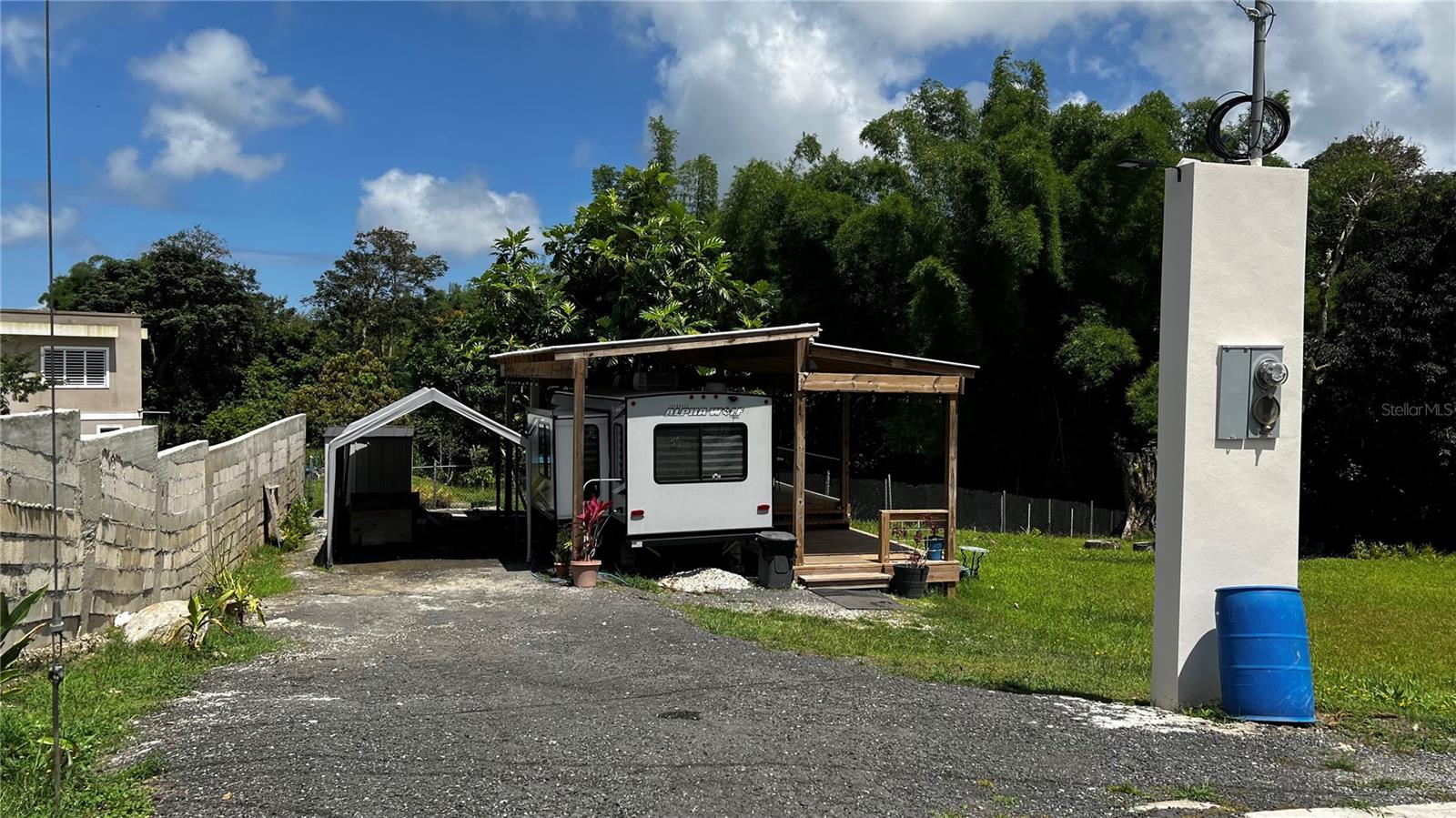 Spacious 1,150 m² residential lot in established Tejas Ward community, Humacao. Level to semi-level topography, trapezoidal shape. FEMA Flood Zone X — minimal risk. Zoned R-G (General Rural/Residential). Active PRASA water and LUMA electricity connections on site. Covered wood structure (625 sf) and septic tank already installed. Access via PR-908 through interior road. Near schools, restaurants, shopping, and major highway access (PR-908 / PR-30). Stable neighborhood, balanced market. SALE INCLUDES: 2021 Cherokee Forest River Alpha Wolf Series M-23RD-L travel trailer (personal property, valued at $20,000). Land + improvements: $104,000. Trailer: $20,000. Total asking: $124,000. Travel trailer legally permitted for residential use by Municipio de Humacao (Permit #2025-628931-PUS-312853, issued Dec 2025, no expiration). Move-in ready day one.