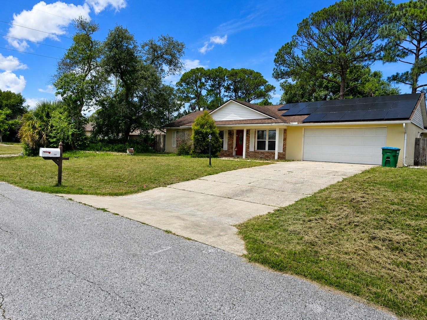 Virtually Staged. Short Sale. NO HOA! Don't miss this incredible opportunity to own a beautifully updated 4-bedroom, 2-bath concrete block home offering approximately 1,588 square feet of comfortable living space in the established Deltona Lakes community. This Third-Party Short Sale presents an exceptional opportunity for buyers looking to build equity while enjoying a move-in-ready home with modern upgrades. New Buyers would qualify for Florida's Homestead Exemption if the buyer meets the eligibility requirements which could lower taxes significantly.
Step inside to an inviting open floor plan featuring luxury laminate flooring throughout the main living areas and ceramic tile in both bathrooms, creating a stylish, low-maintenance living space. The heart of the home is the stunning kitchen, complete with granite countertops, a beautiful decorative tile backsplash, tall cabinetry, a center island, built-in wine rack, and all appliances included—perfect for entertaining or everyday living. Vaulted ceilings and abundant natural light enhance the spacious feel throughout the home.
The private primary suite offers a walk-in closet and  sliding glass doors leading directly to the covered patio, creating the perfect place to enjoy your morning coffee or unwind in the evening. Both bathrooms have been tastefully updated with beautiful custom ceramic tile work that adds elegance and character. Outside, you'll find a large, fully fenced backyard shaded by mature trees, providing plenty of room for pets, family gatherings, gardening, or simply relaxing in your own private oasis. An attached two-car garage, irrigation system, and convenient location near shopping, dining, schools, parks, medical facilities, and major highways make this home an outstanding choice for both homeowners and investors.

This property is being sold as a Third-Party Short Sale and is subject to approval by the seller's mortgage lender and the solar financing lienholder. The existing solar energy system offers the potential for long-term energy savings, subject to the final approved terms of the solar financing. Buyers will have the opportunity to review all available solar documentation prior to closing. Sold As-Is with the Right to Inspect. If you've been searching for a spacious, updated home with NO HOA, modern finishes, a fantastic backyard, and the opportunity to purchase at an exceptional value, this is one you won't want to miss!