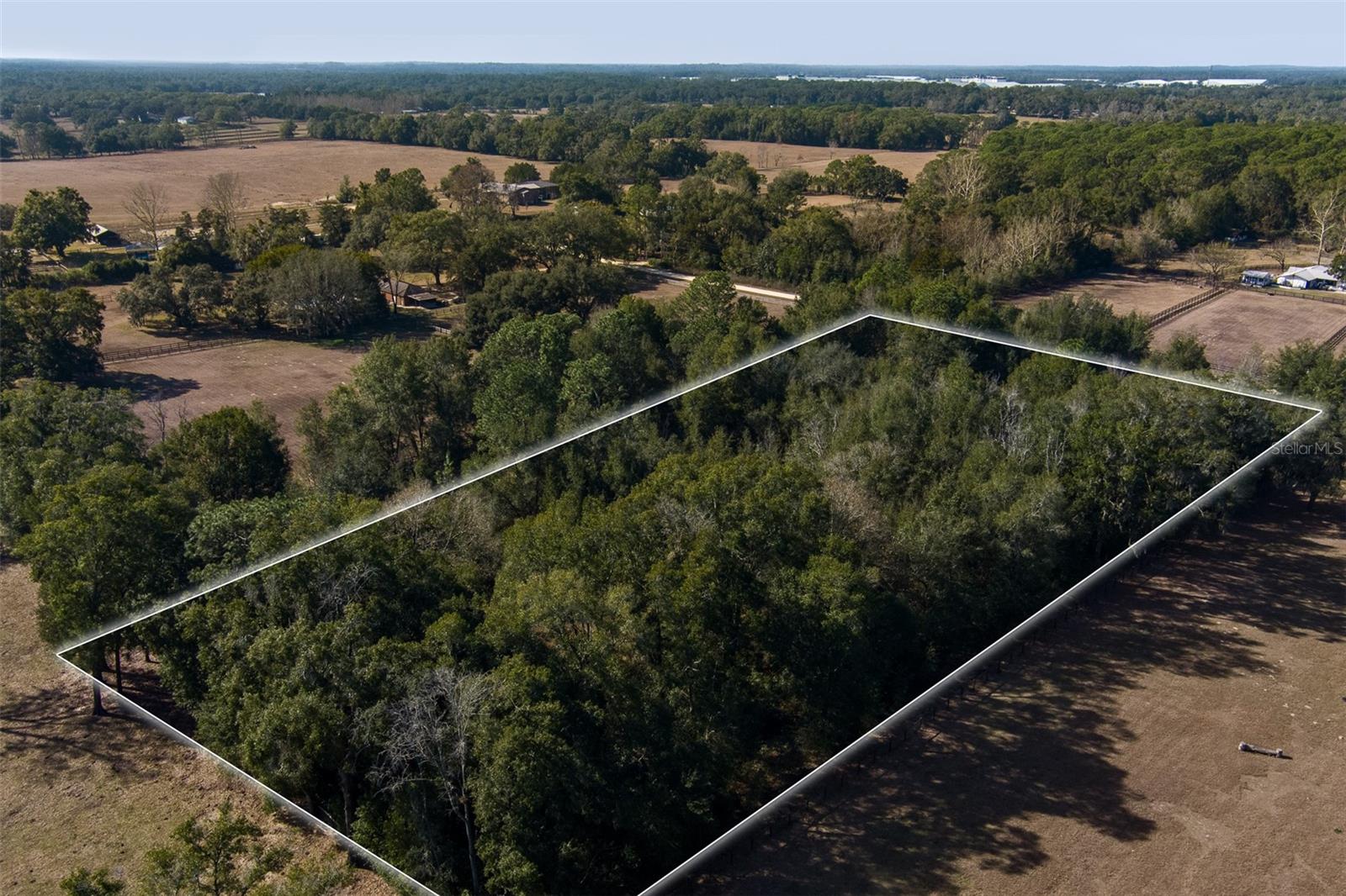 This 5-acre wooded parcel is located in Fantasy Farm Estates in Ocala, situated on a quiet gravel road that offers privacy and a peaceful setting. The property is just minutes from the World Equestrian Center, providing quick access to shopping, dining, entertainment, and year-round equestrian events. A great opportunity to build a home or small farm in a convenient location while still enjoying a rural feel!