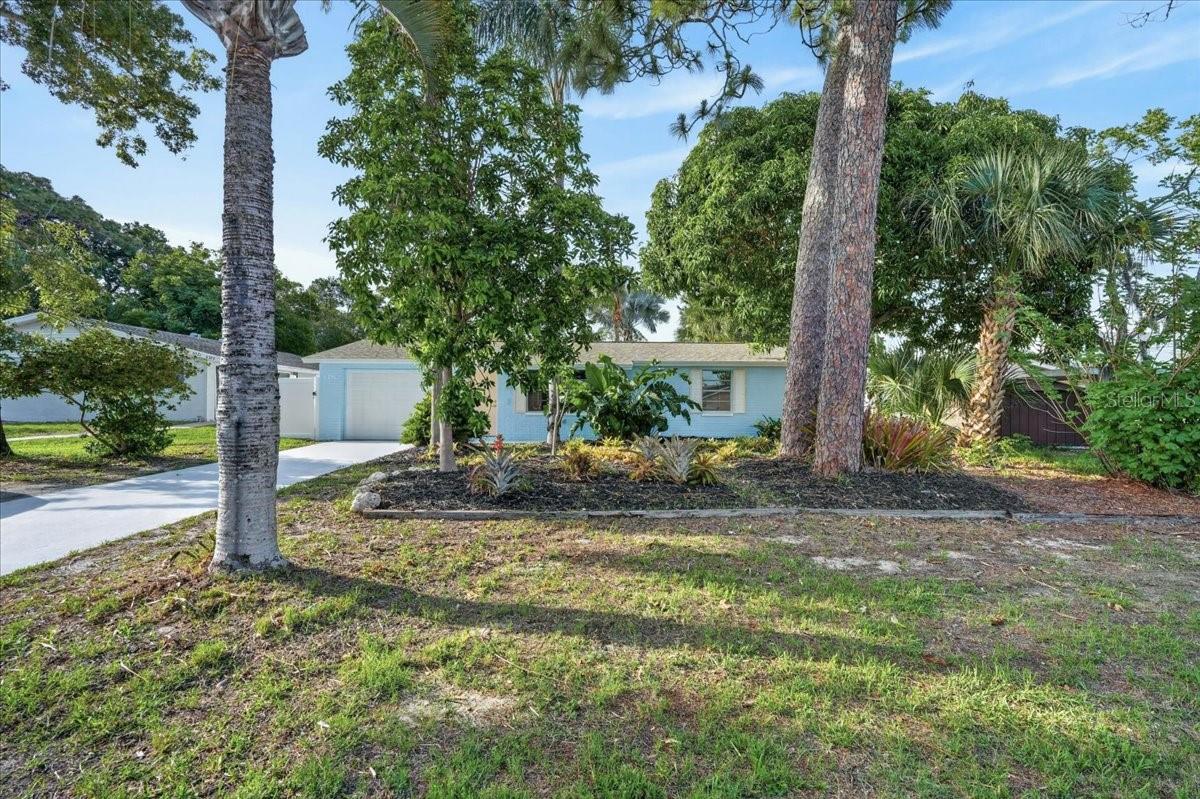 One or more photo(s) has been virtually staged. Welcome home to this beautifully remodeled 2-bedroom, 1-bathroom concrete-block residence, where modern upgrades and thoughtful improvements create a move-in-ready retreat. Nestled on a spacious lot, the property features a large backyard filled with mature tropical palm trees and a private fenced yard with newer vinyl fencing installed in 2024—perfect for entertaining, pets, or simply enjoying your own outdoor sanctuary.

Inside, you'll find new interior and exterior paint along with stunning updates throughout. The completely renovated kitchen boasts new cabinetry, a stylish backsplash, quartz countertops, stainless-steel appliances, and a center island with barstool seating, creating the perfect space for cooking and gathering.

The spacious living room features a cozy fireplace and sliding glass doors that open directly to the backyard, seamlessly blending indoor and outdoor living. New luxury vinyl flooring runs throughout the home, complemented by all-new fixtures, including ceiling fans, lighting, and faucets. The fully remodeled bathroom offers a fresh, modern design with a new tub, vanity, mirror, toilet, and beautifully retiled combo tub and shower.

Additional major improvements include newer remote-controlled ductless mini-split heating and air conditioning units installed in January 2023, a newer roof installed in October 2023, a newer garage door installed in September 2020, and a brand-new water heater.

This meticulously updated home combines style, comfort, and peace of mind with extensive recent upgrades—ready for its next owner to enjoy!