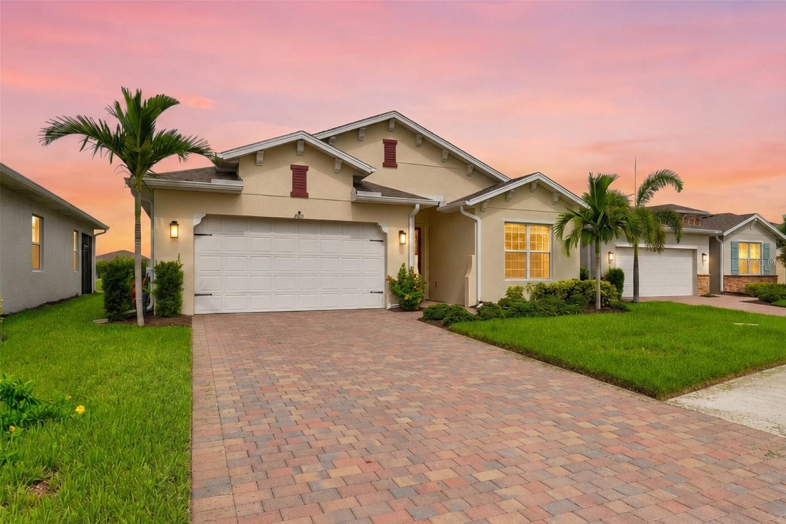 Welcome to one of the most desirable homes in the gated community of The Cove at West Port—a beautifully upgraded Shelby model situated on a premium lakefront homesite with breathtaking western exposure, providing spectacular Florida sunsets from the comfort of your own covered lanai.

Offering 2,221 square feet of thoughtfully designed living space, this exceptional home features 3 bedrooms, a spacious den, 2½ bathrooms, and an oversized 2-car garage. From the moment you enter the impressive foyer, you'll appreciate the elegant tray ceilings, abundant natural light, and the seamless open-concept floor plan designed for both comfortable everyday living and effortless entertaining.

The gourmet kitchen serves as the centerpiece of the home, featuring a large island with bar seating, stainless steel appliances, abundant cabinetry, a generous corner pantry, and expansive counter space overlooking the dining area and great room. Triple sliding glass doors frame stunning lake views and create a seamless transition to the covered lanai, where you'll enjoy peaceful mornings, relaxing evenings, and unforgettable sunset skies.

The private owner's suite is thoughtfully positioned at the rear of the home to maximize the tranquil water views and includes a luxurious en-suite bath with dual vanities, a soaking tub, separate walk-in shower, and an oversized walk-in closet with direct access to the laundry room.

This home has been meticulously maintained and thoughtfully upgraded throughout, including tile flooring in every bedroom, custom window treatments, upgraded designer lighting, six ceiling fans, a professionally finished epoxy garage floor, sealed paver driveway and lanai, and professionally installed hurricane shutters protecting both the front entry door and rear sliding glass doors—providing additional peace of mind during storm season.

The versatile den offers the perfect space for a home office, media room, library, or guest accommodations, while the split-bedroom floor plan provides privacy for family and visitors alike.

Residents of The Cove at West Port enjoy outstanding resort-style amenities, including a clubhouse, fitness center, resort-style swimming pool, pickleball courts, bocce courts, walking paths, and a dog park. Conveniently located just minutes from shopping, dining, golf, boating, world-class beaches, medical facilities, and the Centennial Sports Park, this home offers the perfect balance of luxury, comfort, and the Florida lifestyle you've been dreaming of.

Premium lakefront location. Exceptional upgrades. Stunning sunsets. This is Florida living at its finest.