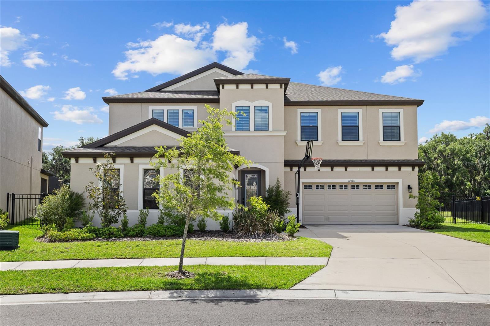 PRIVATE POOL & SPA HOME! WATER VIEW! This extraordinary home features 5 bedrooms, 4 and a half bathrooms, and a 3-car garage. Located in the Hawkstone Community, this 2022 built home has so much to offer. The exterior has great curb appeal with a separate side entry 1-car garage in addition to a full 2-car garage. Inside the home, is an open foyer with soaring ceilings, an elegant chandelier, and a grand staircase. WOOD TILE FLOORS THROUGHOUT! There is an office and formal dining room near the entry way and a convenient downstairs half bathroom. The kitchen has it ALL, with features including a center Island with extended seating, modern stainless-steel appliances with a gas cooktop and built-in oven, stainless range hood, farmhouse sink, cabinetry with crown molding and fully extended past the breakfast nook, stone countertops, tiled backsplash, and a walk-in pantry! The kitchen overlooks the family room for an open concept living space, perfect for entertaining guests. There is a private guest suite with it's own bathroom for extra privacy. The second floor has a BONUS ROOM AND UPSTAIRS BALCONY, for endless possibilities, as well as the remaining bedrooms and bathrooms, two joined with a jack and jill bathroom and the 4th bedrooms with an additional full bathroom. The primary suite has a spacious ensuite bathroom with two separate vanities with sinks, separate tiled garden tub & fully tiled walk-in shower, plus an OVERSIZED WALK-IN CLOSET. The backyard is your own private oasis with a HEATED POOL & SPA BUILT IN 2023, fully caged with the screened in lanai, overlooking a beautiful pond view to really enjoy those Florida sunsets, and with a spacious fenced in yard! NO REAR NEIGHBORS! The Hawkstone community has so much to offer, a dog park, two pools, playgrounds, sports courts, trails, and a dock! Your opportunity awaits! Call today to schedule your private viewing!