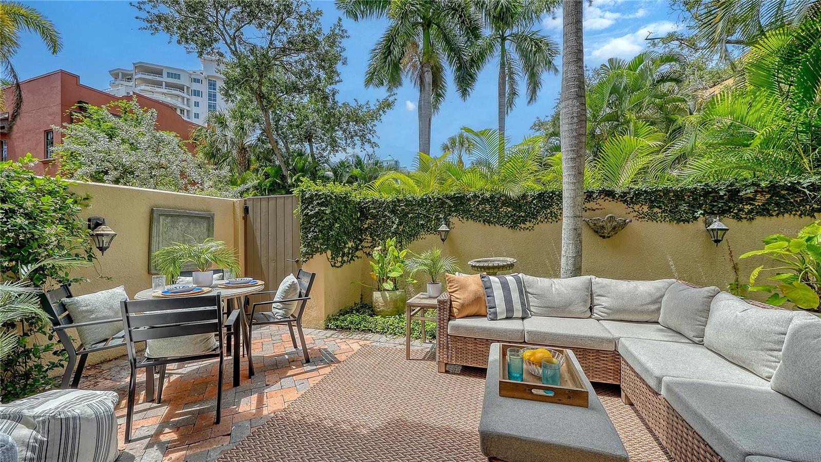 Located in the heart of Sarasota’s iconic Burns Court district, this beautifully updated two-story, three-bedroom residence blends the privacy and comfort of move-in ready single-family living with the walkability, charm, and energy of downtown just outside your door. 
Spanning nearly 2,000 square feet, the thoughtfully designed layout is enhanced by multiple outdoor living spaces, including the largest private courtyard in the community and three separate bedroom balconies. Beyond the solid mahogany front door, refined interiors showcase travertine flooring, crown molding, high ceilings, impact-rated windows and doors, and an abundance of natural light throughout.
The main level is designed for effortless everyday living and entertaining, flowing seamlessly from the formal living room—anchored by a gas fireplace and custom built-ins—to the dining area and sunlit family room overlooking the lush courtyard. The 2023-remodeled gourmet kitchen is appointed with custom wood cabinetry featuring soft-close drawers and pull-out storage, under-cabinet lighting, thick quartz countertops, and an oversized island with seating. Premium appliances include a Sub-Zero refrigerator, Viking gas range and hood, and Miele dishwasher, while upgraded LED lighting enhances both ambiance and functionality. 
Upstairs, Brazilian cherry engineered hardwood flooring leads to a serene primary suite featuring a private balcony, custom walk-in closet, and a fully renovated en-suite bath completed in 2025 with dual quartz-topped vanities, a tile-and-glass walk-in shower with bench seating, and a dedicated makeup area. Two additional guest bedrooms—each with its own balcony—share a beautifully updated bath with designer finishes. A second-floor laundry room with additional storage cabinetry adds convenience.
Burns Court Villas is known for its tranquil, tucked-away atmosphere in the center of downtown Sarasota, offering covered trellised walkways, lush tropical landscaping, peaceful fountains, and charming courtyard spaces that create a uniquely serene residential setting. Residents enjoy a heated pool and spa, lounge area with outdoor fireplace, secure parking, fob-access gates, and enhanced perimeter security. The association also covers many utilities and services, including management, grounds maintenance, pest control, water, sewer, and waste collection. 
Perfectly positioned moments from downtown Sarasota’s Cultural Coast, this residence places you near Marina Jack, the Bayfront, theaters, galleries, farmers markets, boutique shopping, and acclaimed dining along Main Street. St. Armands Circle, Lido Beach, and Sarasota’s Gulf beaches are just minutes away, creating an exceptional opportunity to enjoy refined downtown living paired with Sarasota’s celebrated coastal lifestyle.