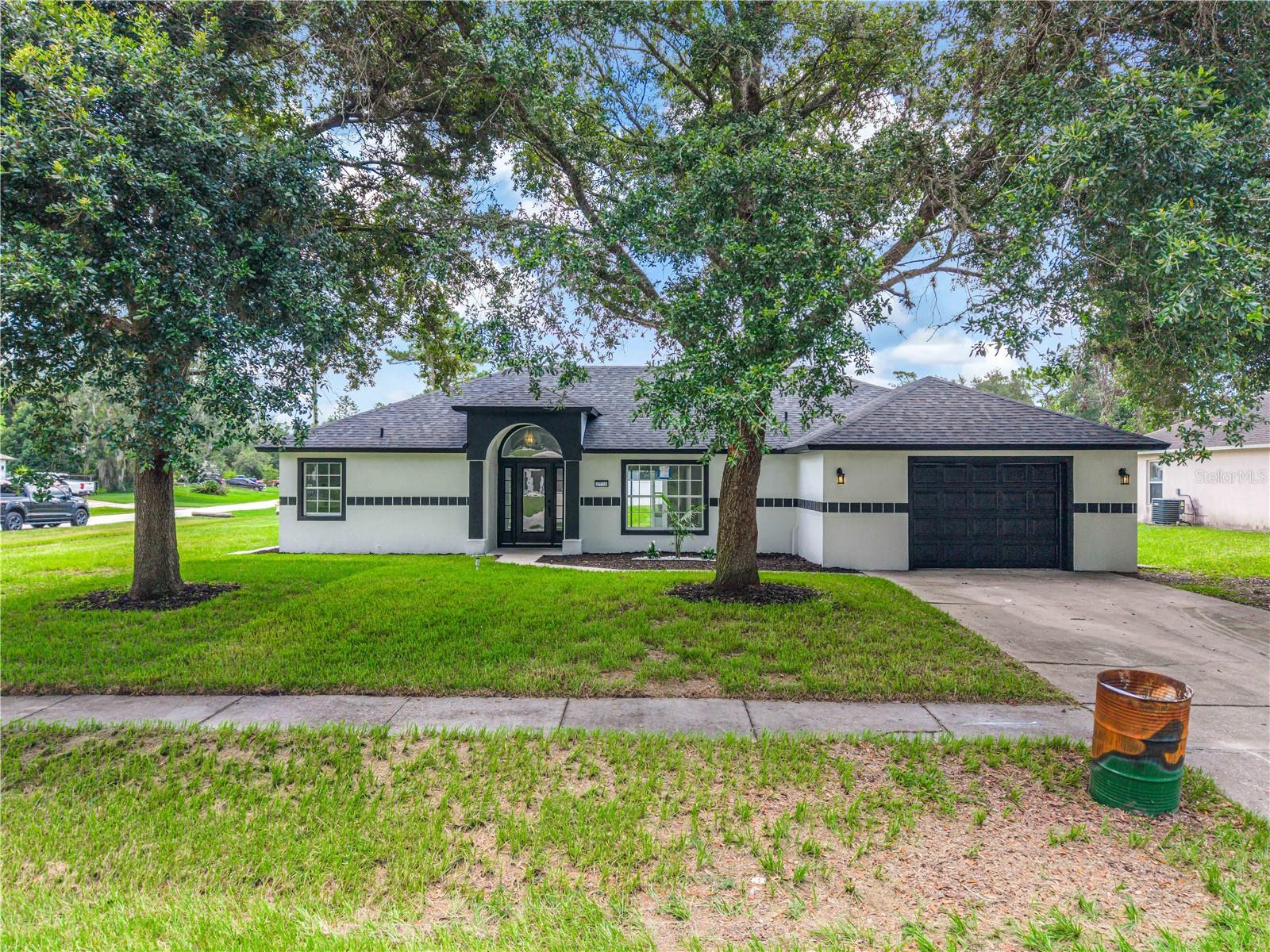 Beautifully renovated from top to bottom, New Roof, New A/C, New Water Heater. This move-in ready 3-bedroom, 3-bathroom home in the heart of Deltona offers the perfect blend of style, comfort, and convenience. Ideally located just minutes from major roads, schools, Publix, and Lowe's, this home provides easy access to everyday essentials while maintaining a peaceful residential setting. Step inside to discover fresh, modern updates throughout, including new interior paint, new flooring, updated lighting and Fans, open layout. The beautifully redesigned kitchen features timeless shaker cabinetry, sleek countertops, and stainless-steel appliances, creating a stylish and functional space for cooking and gathering. Just off the kitchen, you will have access to the freshly painted one-car garage. The house provides a laundry room.  The bathrooms have been tastefully updated with new tile, modern vanities, updated lighting, and full-size tubs. The spacious primary suite offers a relaxing retreat complete with a large walk-in closet. Additionally, the house provides a large family room, the improvements continue with fresh exterior paint, updated landscaping, fencing and an enormous garage/workshop sit at the back of the property ready to serve multi-purposes. This beautifully updated home is truly moving-in ready—schedule your private showing today!