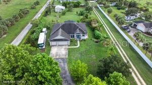 Situated at the center of the Space Coast's aerospace industry this one-acre residence offers unparalleled proximity to SpaceX, Blue Origin, and NASA. Innovation meets home with front-row access to rocket launches! This spacious home features 7KW solar panels to run the house, Tesla charging station, and an open floor plan for relaxing or entertaining. Private guest/in-law suite with hidden safe room is a bonus feature! Layout offers dining area plus a breakfast nook, great room with triple pocket sliders, covered patio, and a large 3-car garage! Primary suite boasts a soaker tub, seamless shower, double sinks and dual closets plus doors to the exterior! 20x60 workshop for all your projects with two rolling doors! Room to roam in the huge backyard with sprinkler system and mango, avocado, lychee, mulberry, guava, macadamia nut and pecan trees! This is the perfect escape from the hustle bustle of daily life! Come see this piece of paradise today!