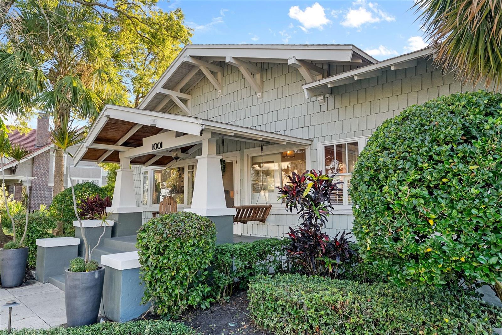 Welcome to 1001 South Oregon Avenue, a stunningly restored and reimagined historic bungalow nestled on a coveted corner lot in the heart of Tampa’s most prestigious neighborhood—Hyde Park Village. Offering the perfect blend of classic charm and contemporary luxury, this five-bedroom, four-bath residence is a rare architectural jewel with panoramic views of the Bay and effortless access to the neighborhood’s premier dining, boutique shopping, and entertainment. From the moment you arrive, the expansive front porch invites you into a home where craftsmanship, elegance, and thoughtful design meet. Step through the historic wood front door into a light-filled interior curated by renowned designer Thomas Lamb, where smooth plaster walls, a soft neutral palette, and refined finishes offer a fresh, timeless canvas anchored by the home’s original architectural details. Soaring vaulted ceilings, an original wood-burning fireplace, and rich millwork nod to the home’s historic roots, while custom upgrades—including a corner sunroom/office with built-ins and natural wood walls, a generous formal dining space, and a chef’s kitchen—deliver modern-day functionality. The kitchen is a showpiece in itself, featuring a Sub-Zero refrigerator, Viking range, Bosch dishwasher, wine fridge, ice maker, second prep sink, and an antique mirrored backsplash that adds a touch of old-world glamour. Designed for seamless indoor-outdoor living, the backyard retreat features a clean-lined pool and spa, lush artificial turf, a side garden with Italian gas-fired pizza oven, and a screened-in porch with a fully equipped custom wet bar—perfect for entertaining under the stars. The home’s layout offers flexibility and privacy: there are three bedrooms and two baths on the main level, two of the bedrooms share a bath and the other has its own ensuite bath. Upstairs, the primary retreat serves as a serene sanctuary with tons of natural lights and views of the bay and dual walk-in closets, a linen closet, a private laundry, and a spa-inspired bath with double vanities, a glass walk-in shower, and a freestanding soaking tub. A newly built two-car garage with abundant storage sits at the rear of the property, topped by a private guest apartment featuring its own living room, bedroom, full bath, and washer/dryer—ideal for visitors, in-laws, or an au pair. This exquisite property spans 3,458 square feet, including 2,978 SF in the main house and 480 SF in the guest apartment, and is located in the highly sought-after Gorrie, Wilson, and Plant High School districts.