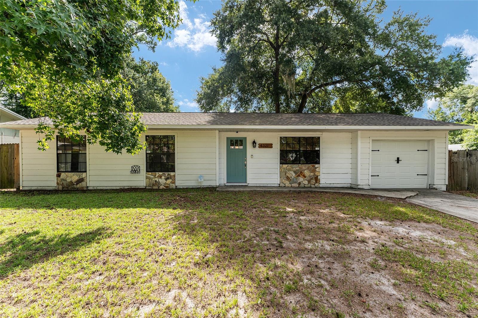Some homes just get it right, and you can tell the moment you step inside.
This three bedroom, two bath home rests on an oversized corner lot in a quiet, tree-lined pocket of northwest Gainesville, with no HOA. Inside, natural light, wood look floors, and soft white walls carry through the space, open and easy from every angle. There's no carpet anywhere, and the layout is natural and unforced, ready to handle a full house of guests and an ordinary Tuesday equally well.
The kitchen is already done, and not the builder grade version of done. White shaker cabinetry, soft-close drawers, quartz counters, stainless appliances, and a patterned backsplash with real character. The island earns its place, and because the kitchen opens to the living and dining space, you're always part of the room instead of tucked away from it.
The backyard is where this home quietly shows off. A deck for slow mornings. A built in bar and grill station for people who love to host. A fire pit ringed in stone, string lights overhead, and a shed to keep everything else in its place. It's built for long dinners and later nights.
The everyday details hold up too. Generous storage throughout, a roof only three years old, and updates already handled. UF, downtown, and a good cup of coffee are all a short drive away. Move in ready in the truest sense, with nothing left to do but settle in.
Some homes take a little imagination. This one just feels right the moment you're standing in it.