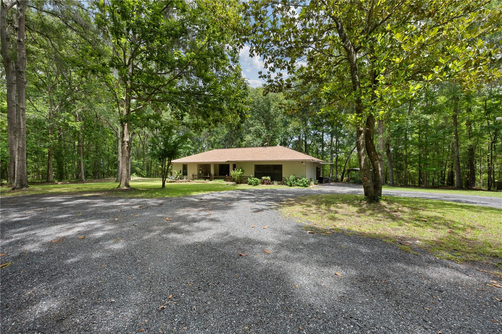 Beyond the trees, down a quiet drive, you'll discover a home where privacy comes naturally and the pace of life slows down.
Nestled among mature woods on 2.44 acres in Northwest Marion County's Farmland Preservation Area, this thoughtfully remodeled western-inspired home provides a level of seclusion that is becoming increasingly rare. Hidden from the road and surrounded by trees, the property feels like a private retreat while remaining in the heart of one of Florida's most desirable rural landscapes.
The surrounding area is defined by sprawling horse farms, multi-generational family-owned farmland, and large-acreage estates that have made this part of Marion County so sought after. Adding to the sense of privacy, the property borders more than 3,000 acres of farmland to the rear, creating a buffer from future development and helping preserve the area's peaceful character.
A charming koi pond welcomes guests at the front porch, while inside, the 2,142-square-foot home showcases thoughtful updates, warm western styling, and comfortable living spaces. The living room fireplace creates a natural gathering place, and a brand-new roof adds lasting value and peace of mind.
With 2 bedrooms, 2 baths, and an exceptionally large bonus room, the home offers flexibility for a variety of lifestyles. Whether you need a home office, hobby room, media room, guest space, or additional living area, the possibilities are endless.
Step outside onto the expansive rear deck overlooking the wooded backyard and enjoy the quiet beauty of your surroundings. Complete with a hot tub, it's the perfect place for morning coffee, evening gatherings, or simply unwinding while watching deer wander through the trees, wild turkey forage nearby, and coveys of quail emerge from the underbrush—daily reminders that you're living in one of Marion County's most peaceful natural settings. 
For buyers seeking additional acreage, the adjacent 3.44-acre parcel is also available for purchase, offering a unique opportunity to expand your footprint in this exceptional location.
If you've been searching for a home that captures the privacy, character, and equestrian-country atmosphere that Marion County is known for, this property deserves a closer look.
