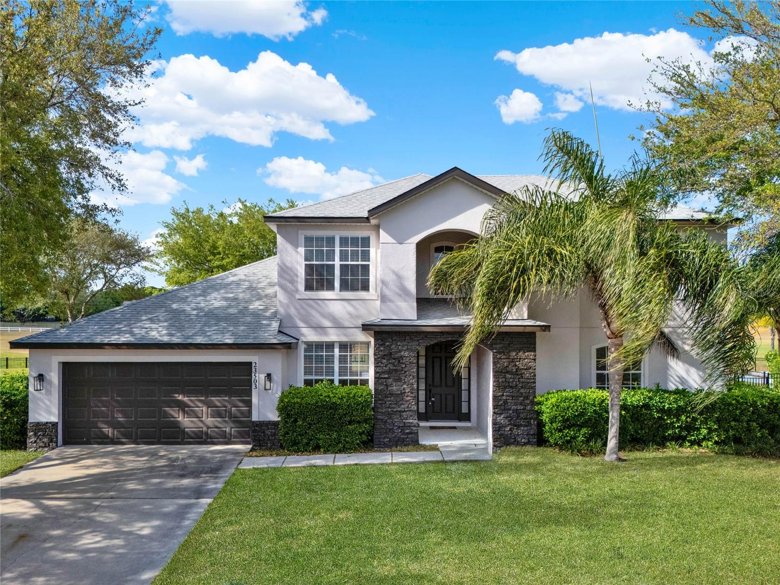 Experience elevated living in this fully renovated golf course estate nestled within the prestigious gated community of Sorrento Springs. Rarely does an opportunity arise to own a beautifully reimagined 5-bedroom residence perfectly positioned on an oversized .37-acre homesite with breathtaking frontage overlooking the 18th tee box of Eagle Dunes Golf Course. Offering 3,443 square feet of thoughtfully designed living space, this exceptional home seamlessly blends timeless elegance with modern sophistication.

From the moment you arrive, the home delivers a striking first impression with mature landscaping, a stacked-stone entry, freshly painted exterior (2024), and a recently replaced roof (2023), providing both curb appeal and long-term peace of mind. Beyond the front door, a light-filled interior welcomes you with soaring ceilings, elegant arched entryways, wide baseboards, designer neutral tones, and a refined blend of warmth and luxury throughout.

Designed with both everyday living and entertaining in mind, the open-concept main level flows effortlessly from the formal living and dining spaces into an expansive great room and chef-inspired kitchen, creating a seamless gathering experience for family and guests alike. Panoramic golf course views provide a stunning backdrop throughout the main living areas and extend into the private backyard retreat beyond.

The gourmet kitchen has been thoughtfully redesigned with luxurious Quartz countertops and a matching full-height backsplash, crisp white custom cabinetry with modern hardware, upgraded stainless steel appliances, a stainless sink with pot-filler faucet, abundant storage, and multiple dining spaces including a breakfast bar and breakfast nook. Beautifully functional and undeniably stylish, this space serves as the true heart of the home. 

Retreat to the first-floor primary suite, a private sanctuary designed with comfort and elegance in mind. Wake up to serene golf course views while enjoying custom wainscoting and an atmosphere of tranquility. The spa-caliber primary bath has been transformed into a luxurious escape featuring a custom dual Quartz vanity, designer lighting, elegant gold accents, a freestanding soaking tub, and a stunning oversized custom tiled shower designed to create a true spa experience at home.

Upstairs, recently installed Oak hardwood flooring adds warmth and character while offering four spacious additional bedrooms and flexible living possibilities for multi-generational families, guest accommodations, home offices, fitness spaces, media rooms, or creative studios.

Step outside and experience your own private outdoor retreat where a covered lanai overlooks the pristine fairways of Eagle Dunes Golf Course. The fully fenced backyard offers exceptional privacy while creating the perfect setting for morning coffee, sunset relaxation, or entertaining family and friends.

Major capital improvements have already been completed, including a 2023 roof replacement, dual A/C systems, upgraded finishes throughout, and stainless steel appliances, allowing you to simply move in and enjoy.

Residents of Sorrento Springs enjoy tranquil tree-lined streets, community events, and convenient access to shopping, dining, medical facilities, parks, lakes, and major roadways. Historic downtown Mount Dora and Eustis are just minutes away, while Orlando International Airport and Florida’s world-famous beaches are approximately one hour away.
