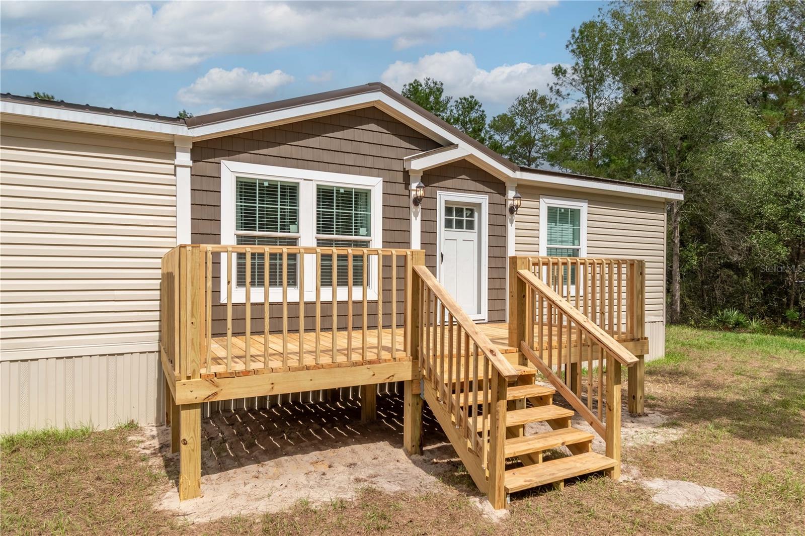 Freshly completed and never occupied, this pristine 2024 manufactured home is ready for its first owner! Fenced and gated on over 3 acres in the peaceful Island Lake Acres community, the property is offered fully furnished with brand-new furnishings throughout, perfect for a seamless move-in or immediate rental opportunity. The 3-bedroom, 2-bath split-bedroom layout offers 1,404 square feet of thoughtfully designed living space. Inside, you’ll find a bright open floor plan that features luxury vinyl flooring, lots of natural light, and modern finishes that combine comfort and style. The kitchen includes an eating nook and comes equipped with stainless steel appliances, a large center island with breakfast bar, and ample cabinet and counter space. A separate laundry area with washer and dryer is also included. Step outside to enjoy expansive outdoor living spaces, including a generous 10 x 32’ rear deck ideal for entertaining, grilling, or simply enjoying the quiet country setting, and an 8 x 18’ front deck perfect for making a first impression. The property's layout is ideal for those seeking room to breathe, create, or expand. A pole barn with water and power service is in place, including multiple electrical outlets, ideal for workshop use, vehicle or equipment storage, or future hobby farming. An additional storage shed also offers water and electrical hookups, making it highly adaptable for a range of uses. Utilities are fully connected, with a private well, septic system, electricity, and high-speed internet access available, and the zoning allows for flexibility with no HOA or deed restrictions to limit your plans. Located within walking distance of Island Lake and Pegram Lake, this property is an ideal option for those looking to spend time on the water. Lake Ocklawaha is also a short drive away, opening up larger options for fishing, boating, and exploration. This home offers a rare mix of modern convenience and rural privacy perfect for full-time living, a seasonal retreat, or even a fully equipped weekend getaway. With ample space, upgraded features, and all the essentials already in place, this is Florida country living at its most comfortable and convenient!