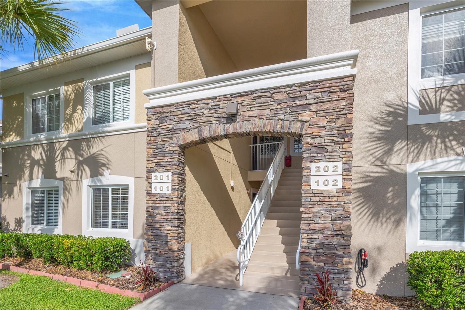 One or more photo(s) has been virtually staged. Welcome to Anand Vihar, Wesley Chapel's premier gated 55+ community, where luxury, convenience, and maintenance-free living come together in this never-lived-in, fully furnished 3-bedroom, 2-bath Club Villa condominium.

Located on the second floor, this desirable split-bedroom floor plan offers a bright, open-concept design with upscale finishes throughout. The spacious kitchen serves as the heart of the home, featuring beautiful quartz countertops, 42-inch soft-close cabinetry, stainless steel GE Profile appliances, abundant workspace, and a breakfast bar that opens seamlessly to the living and dining areas—perfect for both everyday living and entertaining.

The owner's suite provides a peaceful retreat with dual walk-in closets and a luxurious en-suite bath featuring a large walk-in shower. Two additional guest bedrooms and a full bath offer comfort and privacy for family and visitors. Tile flooring throughout, crown molding details, upgraded finishes, and the convenience of being completely move-in ready make this home an exceptional opportunity.

Step outside to your private screened lanai and enjoy tranquil landscape views, or take a short stroll to the spectacular Anand Vihar clubhouse. Residents enjoy an unmatched resort-style lifestyle featuring a heated pool and spa, state-of-the-art fitness center, steam rooms, yoga and meditation spaces, movie theater, community gathering areas, and scenic walking trails throughout the beautifully maintained grounds.

One of Anand Vihar's most distinctive features is its on-site dining hall, where residents can enjoy freshly prepared meals featuring authentic vegetarian cuisine inspired by the diverse regions of India, creating a truly unique and convenient lifestyle experience.

The HOA fee provides exceptional value and includes cable, internet, exterior building maintenance, insurance, landscaping, irrigation, trash service, and access to all community amenities, allowing owners to enjoy a low-maintenance lifestyle with only water and electric expenses to manage.

Ideally located near The Shops at Wiregrass, Tampa Premium Outlets, The Grove, golf courses, restaurants, medical facilities, Flatwoods Preserve, and major highways including I-75, I-275, and I-4, this is a rare opportunity to own a pristine, move-in-ready home in one of Wesley Chapel's most distinctive and sought-after active adult communities.