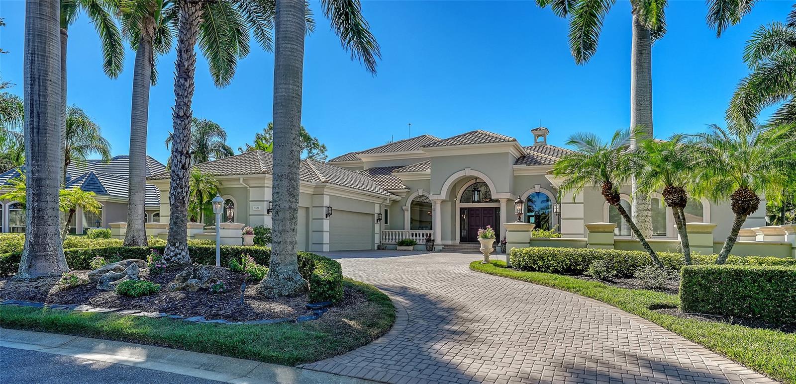 The largest lakefront estate in University Park Country Club, set on nearly ¾ acre offering a rare combination of privacy, golf course views and estate-scale living in one of the most desirable gated communities just minutes from Sarasota. This luxury lakefront residence features an elevator, 4-car air-conditioned garage, resort-style pool and spa, and expansive indoor-outdoor living. Positioned at the end of a quiet cul-de-sac, the property enjoys expansive water views with the golf course beyond—creating a sense of openness and seclusion that is increasingly difficult to replicate. Built by one of Sarasota’s premier builders, the residence is defined by enduring architecture and exceptional craftsmanship, with travertine and walnut-plank flooring, custom millwork, and generous room proportions throughout. Recent updates, including re-surfaced pool & spa, quartz kitchen countertops, fresh interior paint, updated lighting, and window treatments, enhance the home while presenting a compelling opportunity to further modernize to today’s preferences. The chef’s kitchen anchors the home, equipped with custom cabinetry, a Butler’s pantry, and premium appliances including a six-burner Wolf range, Sub-Zero refrigeration, multiple dishwashers, and a built-in Miele coffee system. The first-floor primary suite offers a private retreat with fireplace, custom closets, updated lighting, electronic shades, and direct access to the pool and courtyard. Upstairs, accessible by elevator or grand staircase, are a dedicated theater, expansive bonus room with full bar, guest suite, and covered terrace. Outdoor living is central to the experience, with an infinity-edge pool and spa, gazebo, outdoor kitchen with fireplace, and mature landscaping framing the lakefront setting. Additional features include a golf cart bay, whole-house generator, water filtration system, smart lighting, and fully fenced rear grounds. For buyers seeking a private, estate-scale lakefront property within University Park—where lot size, setting, and construction quality are increasingly rare—this offering presents a compelling opportunity. Conveniently located near University Town Center, fine dining, downtown Sarasota, and SRQ Airport.
