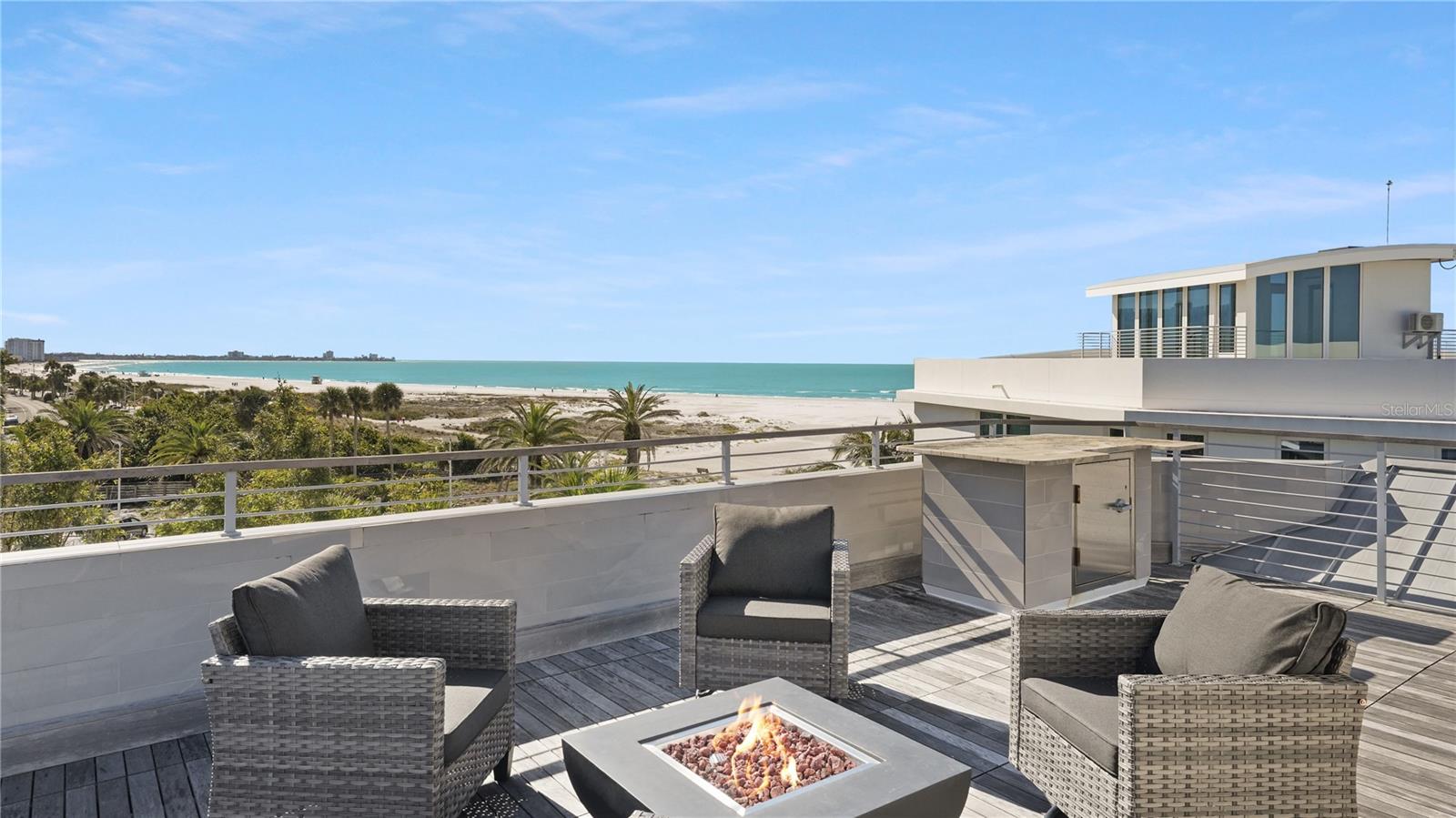 Prepare to be captivated by the meticulous upgrades and contemporary elegance of this stunning Gulf-front, Lido Beach home. Every detail of this thoroughly designed residence, just steps from the pristine Gulf shores, has been carefully crafted to create a modern oasis. Spearheaded by Trinity Construction and Design, the renovation has transformed this home into a masterpiece of modern living. Step inside through the mahogany front door, and you'll immediately be greeted by the breathtaking floating staircase, a true statement piece crafted from beautifully stained solid wood and accented with glass. This sleek and contemporary design sets the tone for the entire residence, offering a seamless blend of modern luxury and coastal charm. Notable exterior upgrades include a newer metal roof, a redesigned facade, and the addition of a fourth garage space. Impact windows, sliders, and doors further enhance the home's durability and security, while welcoming in abundant natural light and showcasing stunning beach views. Inside, the attention to detail is evident in every corner of the nearly 6,000 square foot residence. Gorgeous wood and natural stone features, custom lighting, and surround sound throughout create an atmosphere of sophistication and comfort. Walls of glass sliders and oversized windows frame sunny beach vistas, while exceptional accent walls and floating cabinetry add to the home's contemporary allure. Balconies to the north and south offer seamless transitions to outdoor living on every floor. A convenient three-stop elevator takes you to the first living level, where you'll find the main living area, including the primary bedroom with a spa-inspired en-suite bathroom and an extensively built-in closet spanning 22 feet. Two guest suites, a study, and a bonus room, currently used as a reflexology room, complete this level. On the third level, the open layout comprises the great room, dining area, and media room, making it ideal for entertaining. The chic eat-in kitchen seamlessly blends into the decor with hidden appliances, walls of custom cabinetry, and an expansive island featuring a unique butcher block and stone countertop with a waterfall edge. Step out onto the rooftop deck and take in breathtaking views stretching from the Gulf of Mexico to Sarasota Bay and the downtown city skyline beyond. Entertain with ease on the ground level, where a pavered deck surrounded by a stone privacy wall and lush landscaping sets the stage for outdoor gatherings. Here, you'll find a heated swimming pool, spa, and open lounging/dining areas, creating a secluded oasis just steps from the beach. This exquisite contemporary residence offers the perfect blend of luxury and convenience, with its prime location within walking or biking distance of Sarasota's most sought-after attractions. Close to St. Armands Circle, downtown Sarasota, the bayfront, theaters, museums, trendy eateries, and boutique shopping, this move-in ready home invites you to experience the best of the "cultural coast" lifestyle.