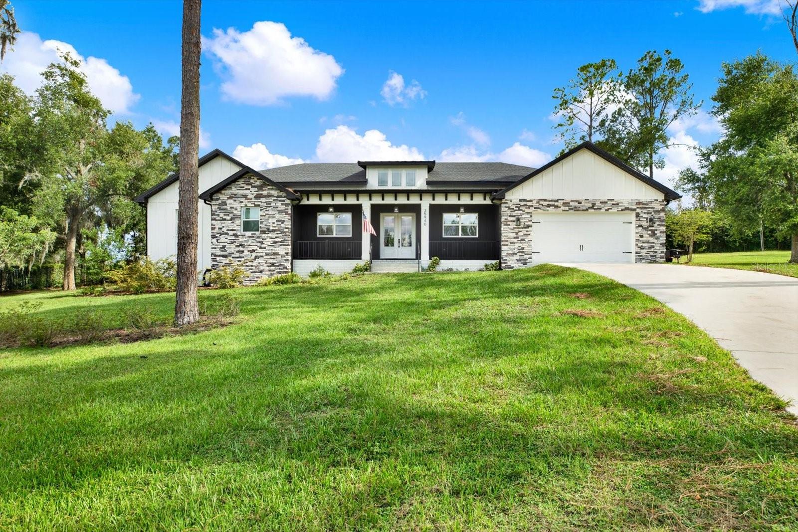 Virtually Staged. One or more photo(s) have been virtually staged. Welcome to your dream home on 0.90 acres! This stunning custom built 2024 farmhouse blends timeless design with modern luxury and exceptional craftsmanship. From the moment you arrive, you’ll be captivated by the beautiful curb appeal featuring brick accents, a board and batten exterior finish constructed of concrete for durability and longevity, and a spacious covered front porch that welcomes you to a grand double door entry. As you step inside, you’ll immediately appreciate the open concept floor plan filled with natural light, soaring ceilings, and thoughtfully designed living spaces that are perfect for everyday living and entertaining. The spacious living room features a stylish wet bar, creating the perfect place to gather with family and friends. The chef’s kitchen is truly the heart of the home, showcasing a large center island with seating, a cooktop with hood, a wall oven, a drawer microwave, a farmhouse style sink, and abundant cabinetry. Tucked behind a charming sliding farmhouse door is an impressive butler’s pantry, offering exceptional storage and prep space. Designed with both comfort and functionality in mind, this home offers three spacious bedrooms, two and a half bathrooms, and a dedicated office complete with custom executive built ins. The guest bedrooms are connected by a convenient Jack and Jill bathroom, providing both privacy and convenience for family and guests. Privately situated, the luxurious primary suite serves as a true retreat. Relax in the spa inspired en suite featuring a freestanding soaking tub, dual vanities, an oversized walk in shower, and an expansive California style walk in closet with custom built ins. The well appointed laundry room offers built in cabinetry and a utility sink, providing additional convenience and storage. Additional energy efficient features include spray foam insulation in the attic, enhancing year round comfort and improving the home’s overall energy performance. Step outside to the screened rear lanai, complete with an outdoor kitchen, creating the perfect setting for year round Florida entertaining. The expansive backyard provides ample space for future customization and endless possibilities. Ideally located in Dade City, this exceptional home offers convenient access to the charm of historic downtown, local dining, shopping, parks, and community events. Schedule your private showing today.