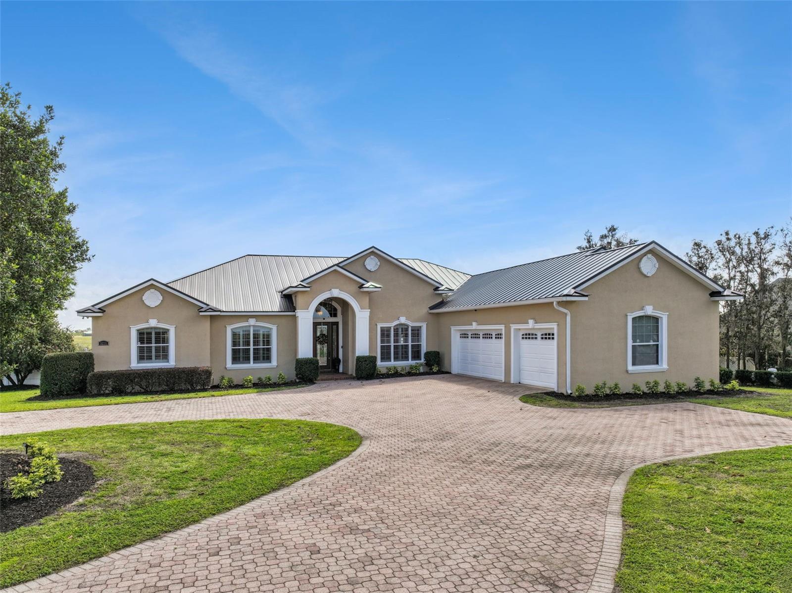 EXPERIENCE THE PINNACLE OF LAKESIDE LIVING on this sprawling 2.34-acre estate overlooking the pristine waters of Blue Lake. This custom-built masterpiece spans 3,152 sq. ft. of meticulously designed living space, where every detail, from the intricate millwork to the soaring tray ceilings, whispers luxury. The heart of the home is an expansive open-concept family room that flows effortlessly into a chef’s kitchen. Outfitted with handsome wood cabinetry and a massive social island, the kitchen serves as a hub for both daily life and grand entertaining. Throughout the home, gorgeous wood flooring is complemented by the earthy elegance of travertine tile in all wet areas. Formal living room and formal dining room link comfortably within the open concept living space. The owners’ retreat is an elegant sanctuary featuring private lanai access, custom-shelved walk-in closets and a spa-like en suite with a soaking tub, walk-in shower and granite-topped split vanities. The split-plan gives privacy where the second bedroom enjoys its own full bath, while the third bedroom is currently a professional home office offering convenient access to a pool-side bathroom. The real showstopper of this home is the massive lanai with a cathedral cedar ceiling, an impressive outdoor kitchen with and a sparkling pool overlooking the lake. It’s not just a home; it’s a vacation you never have to leave! This fabulous home is ideal for the family who loves lakefront living and those who enjoy entertaining. The entire home is equipped with a Generac whole-house generator, providing added comfort and peace of mind. Blue Lake is a 105 acre lake with a mean depth of 20 ft./max depth of 66 ft. Located just a short distance to US Hwy 27 & SR-Hwy 60, near all shopping, Lake Wales or Winter Haven, a great Central Florida location! Call today this is a Must See!