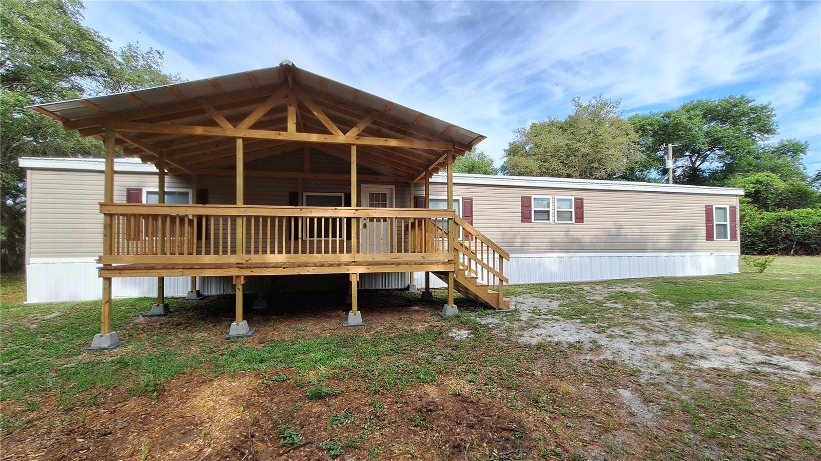 4 bedroom, 3 full baths & 1 half bath. 1.31 acre semi secluded flag lot. Owner will financed with $50k down. Located in Eagles Landing. Updated with metal roofing. Built in 2000 completely renovated in within the past 5 years. 27'x76' manufactured home with detached 2 car carport, 10'x20 lawn equipment shed with double drive through doors. 20'x12' front lanai, 12'x16' lanai over looking the back yard. All new carpet and LVP throughout. Kitchen offers all appliances, side by side refrigerator, microwave, dishwasher, range, multiple cabinets, granite counter tops. Butcher block island with electric and additional storage. 2 master bed & baths. The primary master bedroom and bath includes walk in closet, ceiling fan, his & her granite counter top vanity. Oversized tub, custom ceramic tile walk in shower with his/her shower heads and glass enclosure. Main living room has electric fireplace and multiple windows giving views of the back yard. Partitioned dining area with convenient access to the kitchen and den with wood burning fireplace, coat closet. Beds 3 & 4 also have walk in closets. The secondary master also gives you private access to your ceramic tile walk in shower, granite countertop vanity. Laundry room/mud room includes half bath, built in storage for linens and additional space for setting up a folding table. Smoke detectors, updated 50 gal water heater. Updated metal roof with additional insulation when installed. Double pane insulated windows. Marion County Utilities is the water system with a $12.50 base fee per month. Septic is located in the back yard. Additional insulation was added behind the vinyl siding. No HOA to deal with on this one. Come and live in free Florida. Spectrum is the internet provider for this area. Owner will finance with $50k down terms negotiable. A portion of the SE corner of the property is in AE flood zone. If owner financed the owner will not require flood insurance. No structures are in the flood zone.