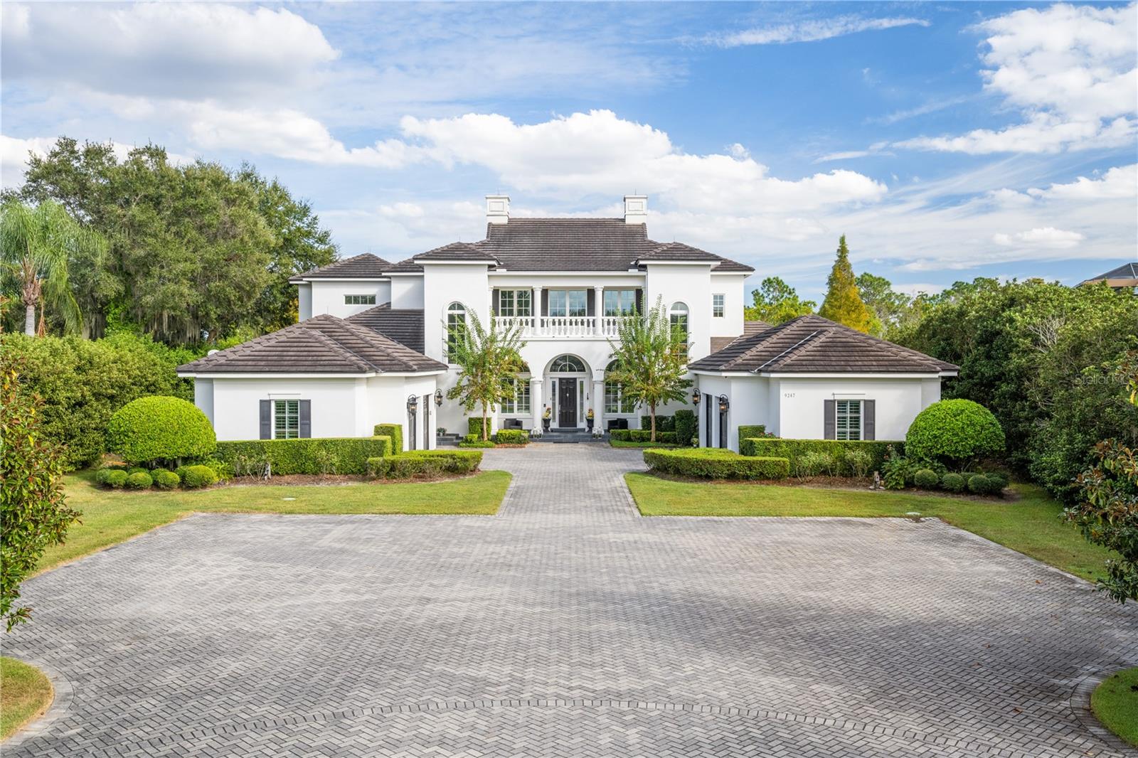 This stunning lakefront home in Keene’s Pointe offers a rare blend of modern Farm Style aesthetics and timeless elegance. Situated on an expansive lot exceeding three acres, this residence was thoughtfully designed just a decade ago, boasting a family-friendly floor plan with 6 bedrooms and 7 bathrooms.

Upon entering, natural light floods the two-story vaulted foyer with a loft, setting the tone for the bright and welcoming atmosphere throughout the home. The main floor features an impressive study, a spacious media room, the primary bedroom suite, and an additional guest bedroom. The Great Room and Open Kitchen concept on this level enhance functionality and create a perfect space for family gatherings.

The focal point of the home is the vast screened pool and lanai area, complete with a cabana-style summer kitchen, an oversized spa, and a generously sized pool featuring five underwater swim stools. Beyond the pool, a dock leads to Lake Tibet Butler, offering a covered boathouse with a lift and double jet ski platforms for water sports enthusiasts.

The upper level hosts four bedrooms and three full baths, arranged in two separate wings connected by a laundry and storage closet. Three of the bedrooms open to a balcony overlooking the expansive pool and lake area, providing breathtaking views.

Practicality meets luxury with an expansive mudroom, a remarkably large and well-organized laundry area, and two oversized two-car garages. The primary side of the house includes an additional garage storage area of 400 sq ft, offering versatile options for a gym, workbench, or golf cart space.

Architect Gregg Hyatt worked with owners to create a thoughtful design that is evident throughout, showcasing beautiful marble finishes, eye-catching chandeliers, and numerous other elegant touches. This home is a must-see to fully appreciate its fabulous floor plan and exceptional features, offering a perfect blend of sophistication and functionality. Don't miss the opportunity to make this unique lakefront property your own in one of Central Florida's most sought after guard gated, golf course country club community featuring an 18-hole Jack Nicklaus Signature Golf Course! Bedroom Closet Type: Walk-in Closet (Primary Bedroom).