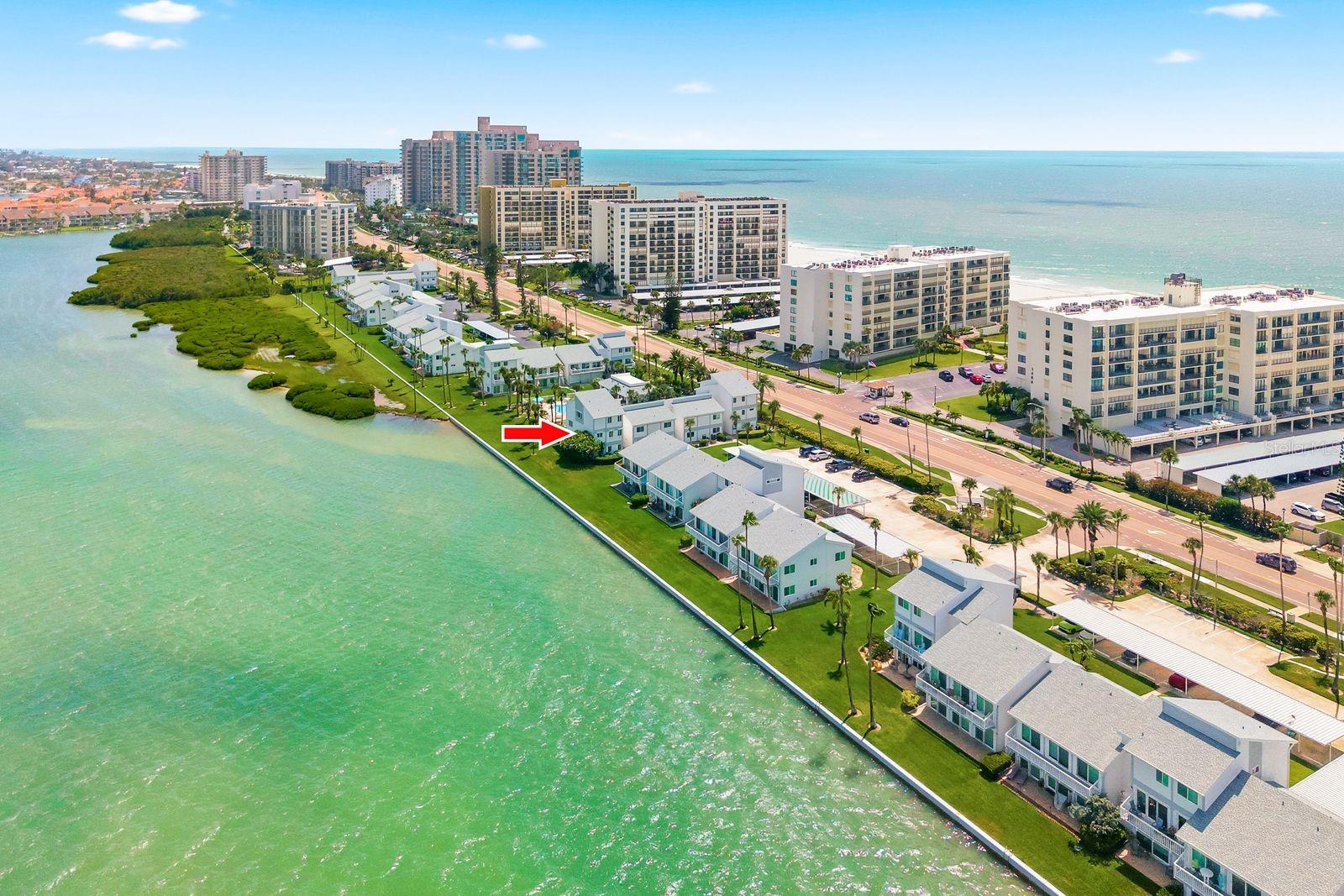 Welcome to Sand Key on Clearwater Beach, where this fully furnished three-bedroom, 2.5-bath townhome offers 1,520 square feet of turnkey, rental-ready living space in Bayside Gardens I. This end-unit residence sits along the Intracoastal Waterway and features incredible water views from every room, including Intracoastal and partial Gulf views. Located just steps from the community pool, the home offers easy access to a heated pool, gas fireplace, grilling area, and covered dining space—perfect for entertaining or enjoying time with family from your balcony.  The roof was replaced in 2025, one AC unit was replaced in October 2025, and the second AC unit was replaced in 2018. The home is approximately 200 feet from the Gulf, making it easy to enjoy the sunsets and white sands of Sand Key Beach. Inside, the open floor plan is ideal for entertaining, with an open-concept kitchen, island, and dining area. Updated Samsung Bespoke kitchen appliances were installed in 2025, and the bright living room features sliders that open to the balcony. Did I mention you can watch the family swim right from your balcony.  A large utility storage closet on the main level provides ample space. Upstairs, the primary bedroom includes an ensuite bathroom, while two additional bedrooms share a Jack-and-Jill bathroom. All living space is elevated on the second and third floors and remained high and dry, with no damage from Helene or Milton. The home also includes a private covered parking space and ample guest parking. Enjoy a prime Sand Key location just minutes from Belleair Beach Marina, the Shoppes of Sand Key, waterfront restaurants, Sand Key Park, the dog park, Clearwater Beach, and other area attractions. The Jolley Trolley offers convenient pickup and drop-off locations in front of Bayside Gardens on Gulf Boulevard. Travel is easy, with Tampa International Airport about 40 minutes away and St. Pete-Clearwater International Airport about 20 minutes away. Move right in, use it as a snowbird retreat, take advantage of the flexible 90-day rental opportunity, and enjoy the pet-friendly policy that welcomes large dogs. This fully furnished home offers the best of Gulf and Intracoastal living.