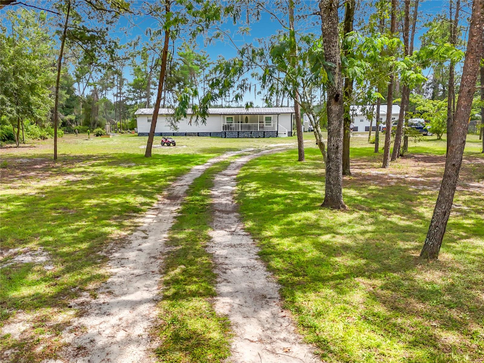 Rare opportunity to own two living spaces on nearly 2 private acres for the price of one! This unique property features a beautifully updated 2-bedroom, 2-bath primary residence plus a detached in-law suite, offering incredible flexibility for multi-generational living, guests, a private home office, or potential rental income. Move-in ready and thoughtfully updated, the main home showcases an open floor plan, luxury laminate flooring, a stunning kitchen with white shaker cabinetry, stainless steel appliances, modern countertops, and beautifully renovated bathrooms with stylish tile finishes. Step outside and enjoy the peaceful North Florida lifestyle with a covered front porch, detached garage/workshop, and plenty of room for RVs, boats, ATVs, gardening, and outdoor entertaining. Situated on nearly 2 acres with public water, public sewer, and no HOA, you'll have the space and freedom to truly enjoy country living. Conveniently located just minutes from Lake Lochloosa, Orange Lake, and numerous parks and wildlife areas offering boating, fishing, kayaking, hiking, and endless outdoor recreation. A short drive to Gainesville provides easy access to the University of Florida, UF Health, shopping, dining, and entertainment while allowing you to return home to the peace and privacy you've been searching for. Whether you're looking for a primary residence with space for extended family, a property with income-producing potential, or simply room to spread out and enjoy life, this one-of-a-kind property offers exceptional value and endless possibilities. Schedule your private showing today!