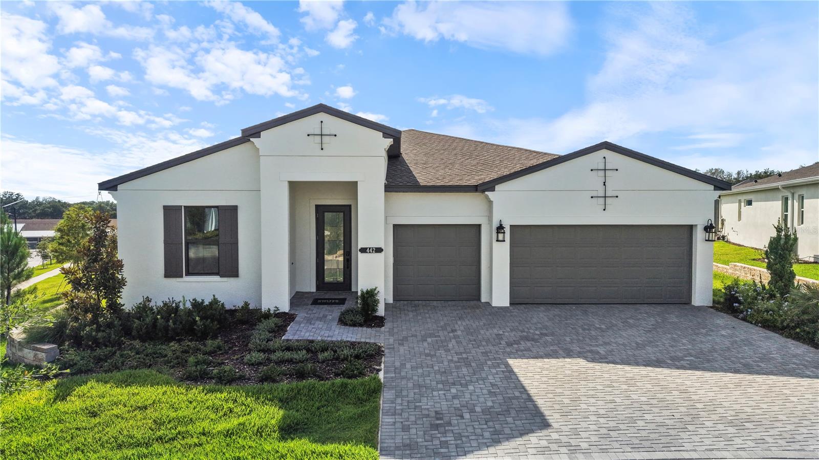 One or more photo(s) has been virtually staged. This move-in ready Pearl floorplan located within Cresswind Hammock Oaks in Lady Lake, Florida offers 3 bedrooms, 3 full baths, a flex room, an extended owner’s suite, and a spacious 3-car garage, all positioned on a premium corner homesite with enhanced landscaping. Designed for both everyday comfort and entertaining, the open-concept layout connects the great room, dining area, and chef-inspired kitchen while a 16-foot sliding glass door creates a seamless transition to the extended covered lanai with privacy wall and future summer kitchen rough-ins. The kitchen is thoughtfully appointed with Monogram appliances, a 36” cooktop, designer hood, waterfall-edge quartz island, artisan backsplash, soft-close cabinetry, and oversized pot-and-pan drawers. Large-format 32x32 polished tile flooring extends throughout the main living areas, foyer, flex space, kitchen, and baths, creating a clean and cohesive design aesthetic. Privately located at the rear of the home, the extended owner’s suite offers additional living space and features a spa-style bath with an oversized frameless shower, tile extended to the ceiling, quartz countertops, ceiling-height mirrors, and designer finishes throughout. Secondary bedrooms are positioned separately for guest privacy, each with access to a full bath. Additional highlights include upgraded interior doors and trim, a designer glass front entry door, spray foam insulation, upgraded carpet padding in bedrooms, enhanced lighting packages, bronze exterior window detailing, and a WiFi-enabled garage door opener. Located within the gated 55+ community of Cresswind Hammock Oaks, residents enjoy access to resort-style amenities, fitness offerings, pickleball, social clubs, and a nationally recognized active adult lifestyle program. See Community Home Guides for details.