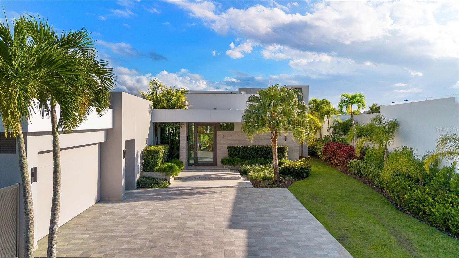 Experience modern luxury at its finest in this Estate home located in The Isles at Dorado Beach, the newest and most exclusive community within the resort. With breathtaking views of the golf course and lake, this property stands out for its exceptional design and unmatched features, including a guesthouse with two additional bedrooms and bathrooms. Spanning 4,065 square feet of interior air-conditioned space and approximately 5,200 square feet of total construction, this home sits on an expansive 1,259-square-meter lot, offering both spacious living and privacy. The main house boasts an open-concept floor plan with high ceilings, a stunning Italian kitchen featuring Thermador appliances, a gas stove, and quartz countertops that beautifully combine elegance and functionality. Each of the four ensuite bedrooms provides comfort and privacy, while a stylish powder room adds convenience for guests. The primary suite is a sanctuary, offering captivating views and direct access to an expanded terrace. Step into the outdoor living space, designed for entertaining, with a custom outdoor kitchen, a temperature-controlled pool and hot tub, and a poolside half bath with an additional outdoor shower. The primary suite’s spa-inspired bathroom includes double showers, a freestanding soaking tub, and a private outdoor shower, creating a serene retreat. The guesthouse, connected by a covered terrace, is perched on the second story and offers two ensuite bedrooms with floor-to-ceiling glass doors and windows, perfectly framing the panoramic views of the lake and golf course. This space is ideal for hosting guests or multi-generational living. Adding to the convenience of living in The Isles at Dorado Beach, the community features a state-of-the-art power generator that ensures uninterrupted power, giving you peace of mind without the hassle or maintenance of owning a personal generator. Professionally decorated by a luxury interior designer and sold turnkey, this home is ready for you to move in and enjoy resort-style living. With limited availability of homes offering views of this caliber, this is a rare opportunity to own a truly exceptional property in The Isles at Dorado Beach. From its thoughtfully curated interiors to its breathtaking outdoor spaces, this estate has everything you need and more. Schedule your private tour today—this home is destined to be in high demand!