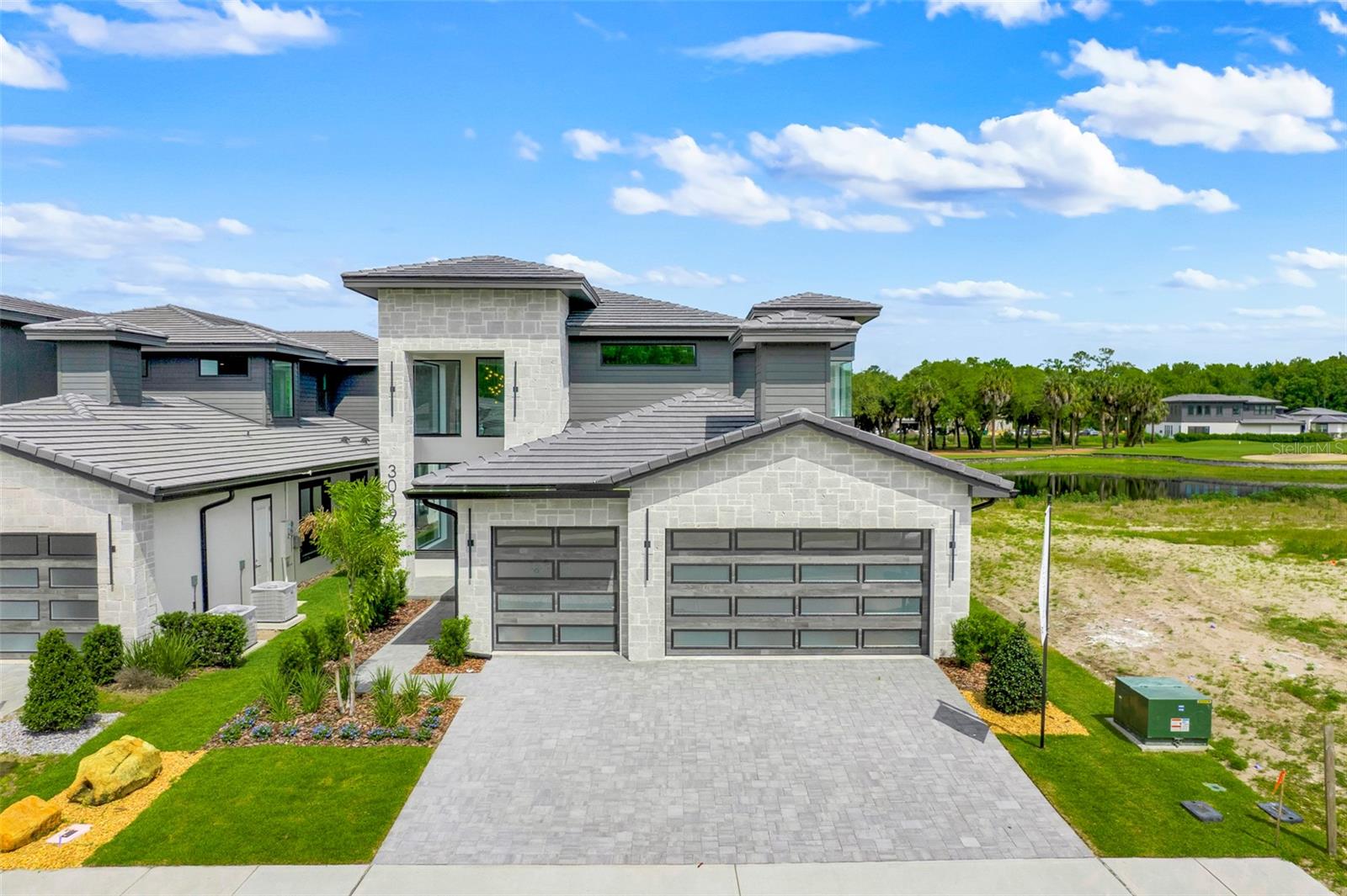 WOW! Newly completed contemporary masterpiece - The Aspen. ABD's award-winning contemporary design for Hampton Green. This incredible 5 bedroom/4 bath home has huge windows that allow in tons of natural light. 3 car garage, first floor primary bedroom as well as 2nd bedroom. 10 foot entry door, contemporary gourmet kitchen with wine fridge plumbing, hidden pantry, phantom automatic roll-up screens on the lanai, huge master suite with lighted mirrors in the bathroom. Upstairs you will find a spacious loft for a second living area, 2 bedrooms, 2 baths and a den/office/optional 5th bedroom. Glass railings and all the high-end finishes you've  to expect from ABD. This home is a palace! Call us today for a showing.