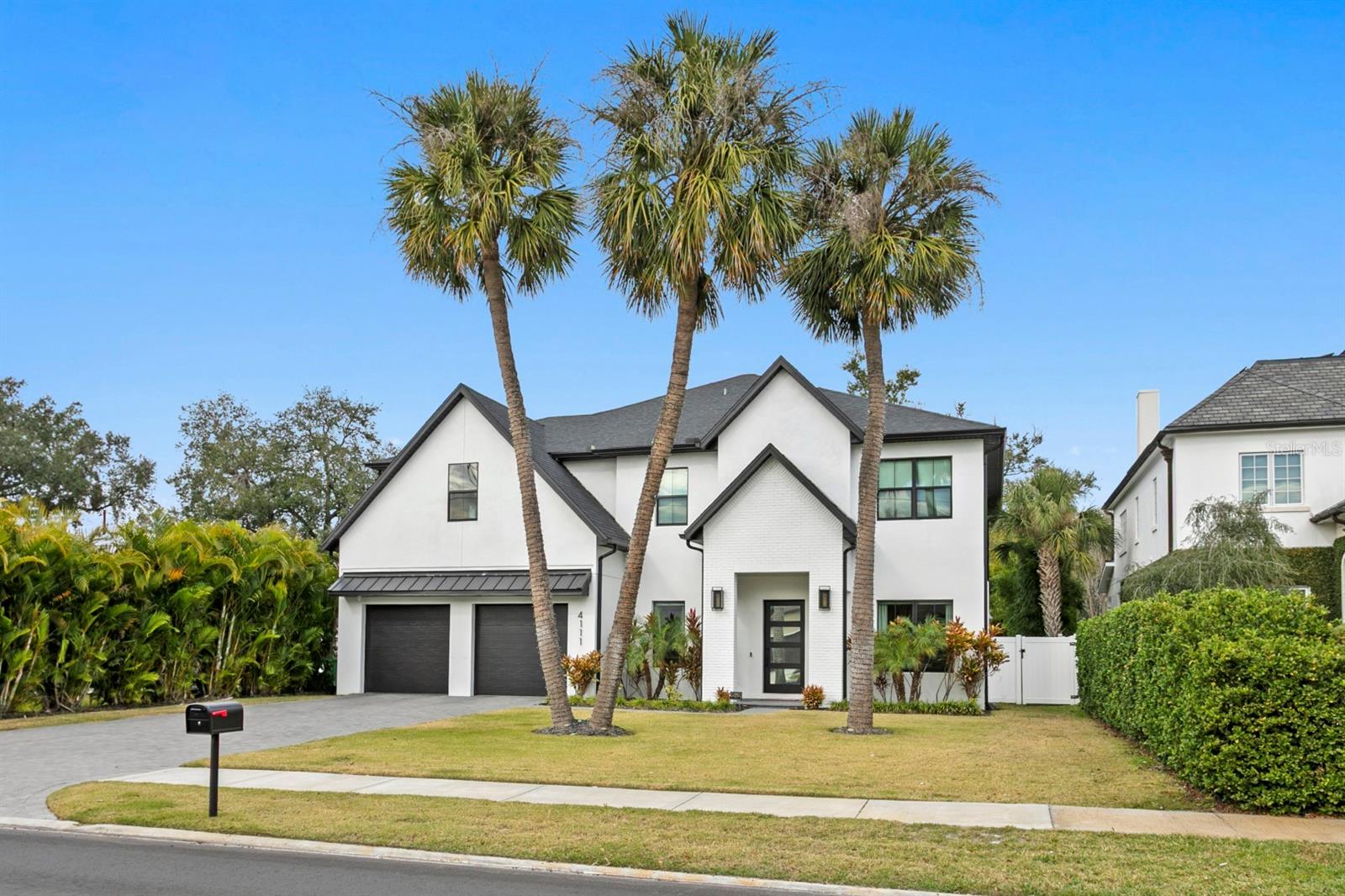 Built in 2022 by Momentum Homes, this residence is ideally located in highly sought-after Swann Estates on a 71 x 134 lot in Flood Zone X (no flood insurance required) and zoned for A-rated Grady, Coleman, and Plant schools. A professional interior designer thoughtfully curated the first floor and primary suite, creating elevated, cohesive spaces that are both beautiful and functional - offering a significant upgrade and sparing buyers the time and expense of designing and furnishing these key living areas. Custom wallpaper, designer lighting, millwork, and carefully selected finishes are seamlessly integrated throughout. This thoughtfully designed, all-block home with impact glass throughout offers 5 bedrooms, 4.5 bathrooms, and 4,532 square feet, including a first-floor bedroom and a dedicated home office. The open-concept living spaces are anchored by a gas fireplace and flow seamlessly into the chef's kitchen, showcasing upgraded Thermador appliances, quartzite countertops and backsplash, custom cabinetry, and a butler's pantry, with direct connection to the formal dining room. A sun-filled breakfast nook provides an inviting space for casual dining. The primary suite is a true retreat, highlighted by a spectacular custom walk-in closet with a large center island. The spa-inspired en suite features a large walk-in shower, separate soaking tub, dual sinks, and LED touch mirrors. Outdoor living is exceptional, featuring a covered lanai with a fully equipped outdoor kitchen, resort-style pool, and a private backyard framed by mature landscaping. Additional highlights include a functional mudroom, thoughtful storage throughout, and a layout that reflects exceptional build quality and attention to detail. Beautifully built and impeccably finished.