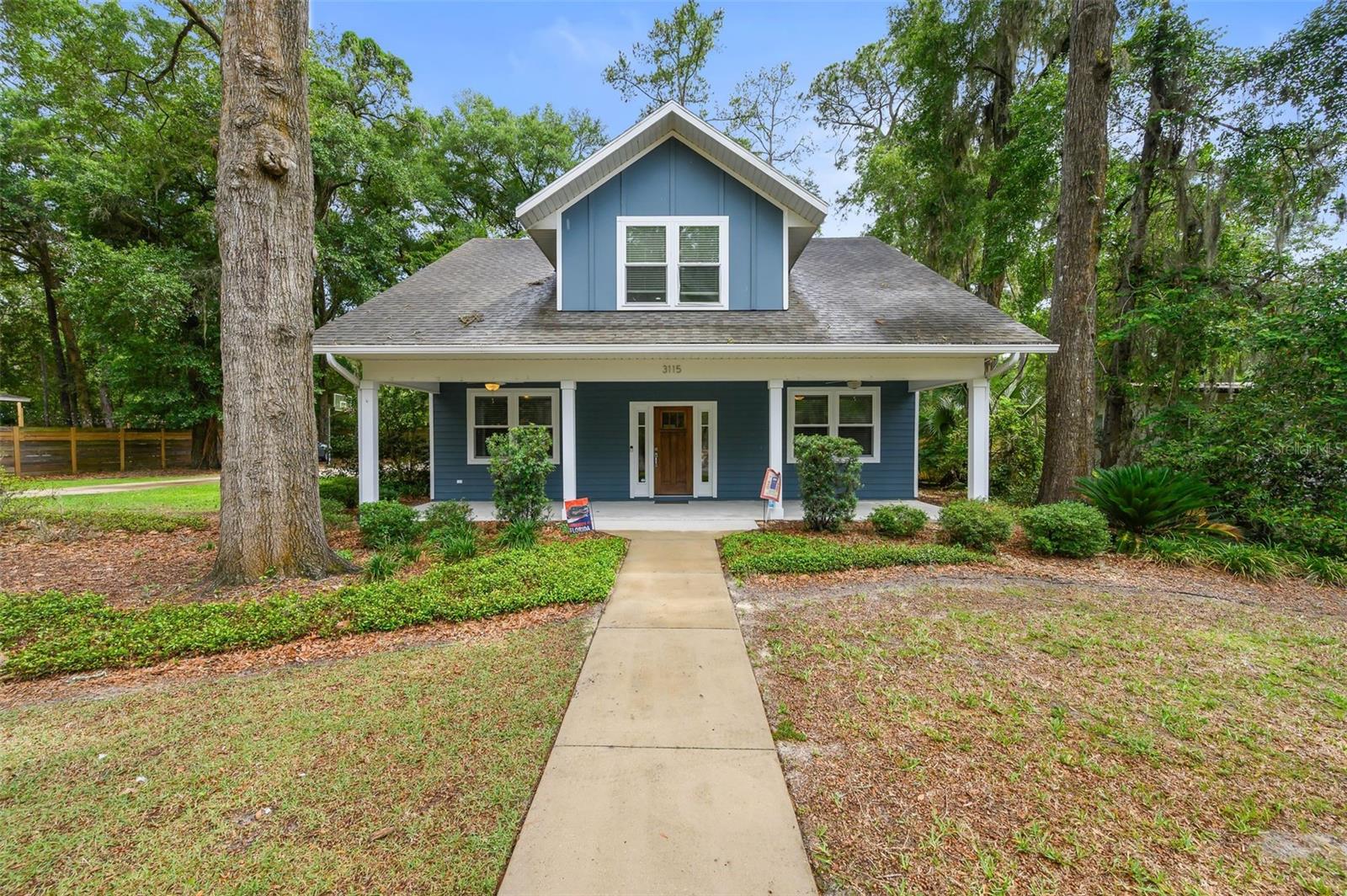 WALK OR BIKE TO UF!!! Opportunities like this don't come along often — a newer construction home with five bedrooms and four full baths, genuinely walkable and bikeable to the University of Florida and the Law School.

Inside, the layout is open and airy, anchored by a generous living and dining area with quartz countertops, stainless appliances, and crown molding. Oversized windows flood the space with natural light, and dual lanai porches give you two separate spots to step outside. Low-E double-pane windows keep things energy efficient throughout.

The main level features two bedrooms (one with an ensuite bath), upgraded wood-look flooring, and easy flow between living spaces. Head upstairs to find three additional bedrooms, two full baths (one ensuite), and a built-in study nook with under-cabinet lighting — a perfect setup for students or work-from-home use.

Almost all of the furniture can be included to make this home turnkey!

The outdoor space is equally impressive: a large lot enclosed by a 7-foot privacy fence, Trex covered deck, fire pit, and a storage shed. The oversized two-car carport comes with plenty of additional parking. A double washer/dryer setup in the laundry room is a practical bonus.

Every bathroom features quartz counters, walk-in showers, and heavy glass doors — finishes that feel more boutique hotel than rental house.
Whether you're looking for a primary residence or an income-producing investment, this home has a track record of consistent rental returns and the flexibility to lease one unit, several rooms, or the whole property.