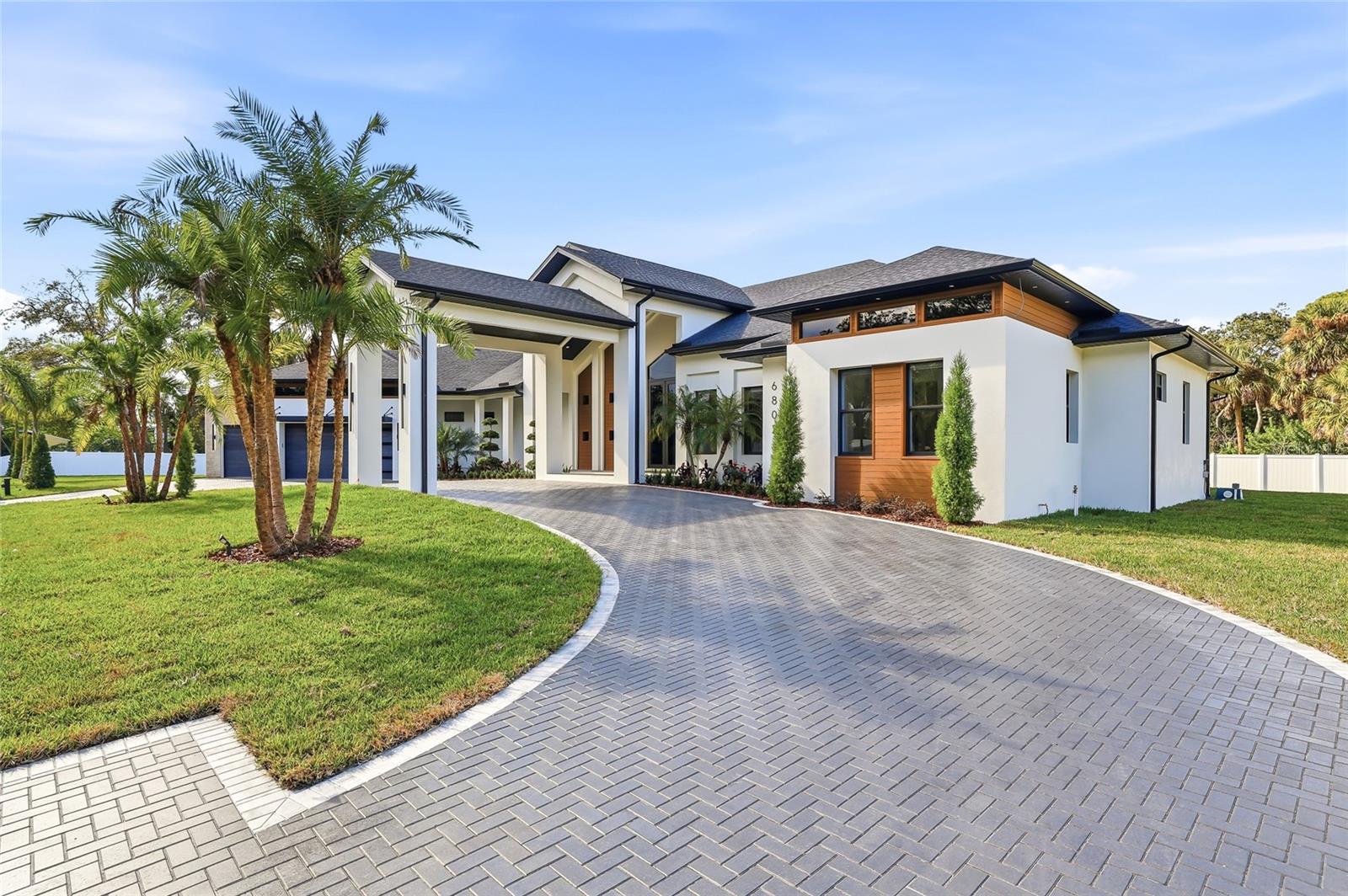 Exceptional new construction luxury home featuring 4 bedrooms, 3 and 1/2 bathrooms, and a 3-car garage, thoughtfully designed with privacy, sophistication, and premium upgrades throughout. The property is fully gated with an electric front gate and perimeter fencing, offering enhanced security and exclusivity. Gorgeous tile flooring flows throughout the entire home, while abundant natural light fills the living spaces, creating an elevated and truly luxurious living experience. High ceilings and custom designer finishes are complemented by motorized interior and exterior window treatments. The modern chef’s kitchen showcases custom cabinetry, a striking 48-inch built-in refrigerator, and high-end appliances, seamlessly opening to expansive living and dining areas. The home also includes a dedicated office, custom wine display with illuminated bar area, built-in entertainment center, and custom cabinetry throughout the kitchen, laundry room, closets, and living spaces.
Outdoor living is equally impressive, featuring a panoramic screened pool enclosure, saltwater pool withl saltwater pool system, fully equipped outdoor kitchen, and an outdoor fireplace—ideal for entertaining year-round. Additional highlights include a covered carport entrance, insulated garage doors, pre-wiring for security cameras, a whole-home sound system with in-ceiling speakers indoors and outdoors, custom designer trim throughout, an irrigation system, and professionally designed landscaping with accent lighting. A rare opportunity to own a truly luxury gem where refined design, natural light, advanced technology, and comfort come together seamlessly. Perfectly positioned in a highly desirable central location, this home offers quick and convenient access to Tampa International Airport, major highways, downtown Tampa, and an exceptional selection of shopping, dining, and entertainment options, delivering both everyday convenience and an elevated lifestyle in one of Tampa’s most sought after areas.