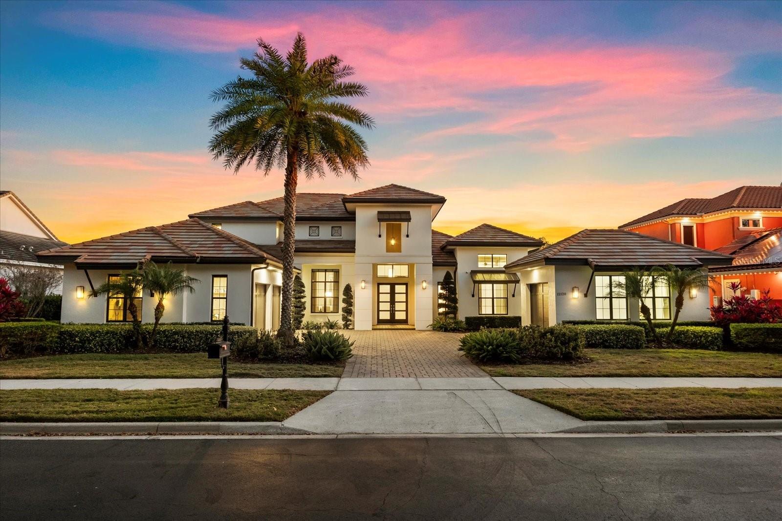 One or more photo(s) has been virtually staged. Experience elevated lakefront luxury living in Windermere with this professionally designed former model home ideally positioned on the shores of Lake Burden. Showcasing 4 bedrooms, 4 full baths, and 2 half baths — including a dedicated pool bath and club room bath — this stunning estate blends timeless architecture, designer finishes, and resort-style outdoor living.

Inside, the palatial great room is framed by rich millwork, intricate ceiling details, wood flooring, a circular wet bar, and a stone-accented wine room, while dramatic 10-foot pocket sliding glass doors open completely to the expansive lanai for seamless indoor-outdoor entertaining. The chef’s gourmet kitchen impresses with a massive waterfall-edge island, chef-grade appliances, and two oversized walk-in pantries, flowing effortlessly into the formal dining room highlighted by a statement mirrored ceiling and the light-filled morning room.

The first-floor primary suite offers tranquil lake views and a spa-inspired bath with a freestanding soaking tub and oversized walk-in shower. A private den and guest bedroom complete the main level. Upstairs, enjoy a spacious club room with wet bar, dedicated media room/home theater, two additional bedrooms, generous storage space, and a covered balcony overlooking the pool and Lake Burden.

Step outside to your private backyard oasis featuring a custom resort-style pool and spa, sunken fire pit lounge, and a fully equipped outdoor kitchen with gas grill, sink, beverage center, and “L”-shaped bar seating — perfect for entertaining or relaxing while enjoying nightly sunset views and Disney fireworks over the water.

Recent updates provide peace of mind, including exterior paint (2021), interior paint (2021 & 2025), new carpet (2021), and tankless water heater (2024).

A rare opportunity to own a luxury waterfront estate in Windermere, this exceptional home delivers elegance, comfort, and unforgettable views in one of Central Florida’s most desirable lakefront communities.