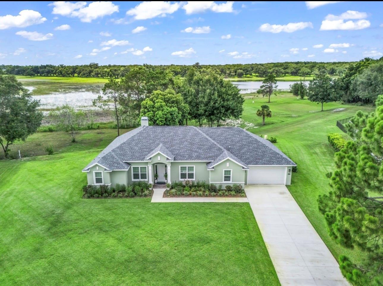 Extraordinary home on nearly 2 acres directly on Lady Lake in the beautiful custom home community of Oak Pointe!
Completed in 2025, this exceptional custom-built lakefront estate is a showcase of timeless elegant design, and the finest in Florida luxury living. Perfectly situated on 1.95 private acres with direct frontage on the waters of Lady Lake, this one-of-a-kind residence offers privacy, breathtaking sunset views, and an unparalleled lifestyle.
Boasting 2,576 square feet of heated and air-conditioned living space and 3751 square feet under roof, this home has been thoughtfully designed with spacious, open-concept living areas, soaring ceilings, plantation shutters and beautiful tile flooring throughout. At the heart of the home, a stunning wood-burning fireplace creates a warm and inviting focal point, blending natural beauty with refined craftsmanship.
The residence features three generously sized bedrooms, two luxurious bathrooms, a private study/library, offering exceptional flexibility for work, relaxation, and entertaining.
The lavish primary suite is a true private sanctuary with stunning lake views, featuring dual walk-in closets and a spa-inspired bath complete with a soaking tub, an oversized walk-in shower, and separate vanities designed for both comfort and convenience.
Indoor and outdoor living come together seamlessly through expansive gathering spaces that open to a spectacular screen enclosed swimming pool and a nearly 400-square-foot screened lanai under-roof featuring a wet bar, ceiling fans and epoxy flooring creating an exceptional setting for entertaining or enjoying peaceful lakefront sunsets.
Car collectors, boating enthusiasts, and hobbyists alike will appreciate the oversized 800-plus-square-foot 4-car garage with front and rear overhead doors, providing easy access for vehicles, boats, golf carts, and recreational equipment.
Located just minutes from shopping, fine dining, The Villages, and Harbor Hills, this extraordinary property offers the rare combination of secluded waterfront living with everyday convenience.
Every detail of this beautiful home has been carefully curated to deliver an exceptional lifestyle where luxury, craftsmanship, and the natural beauty of lakefront living come together in perfect harmony. This is a rare opportunity to own one of Lady Lake's premier waterfront residences.