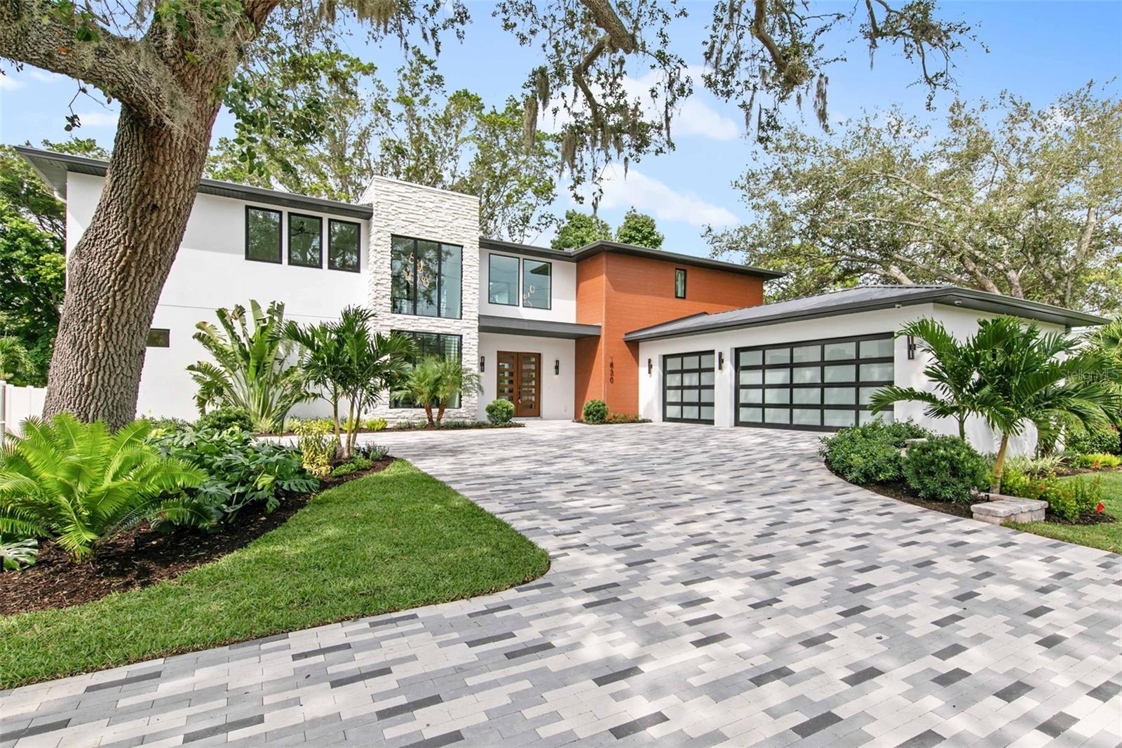 One or more photo(s) has been virtually staged. Welcome to TDI Coastal Homes’ newly constructed masterpiece perfectly situated in the heart of mainland Sarasota, highly sought after for its proximity to top rated schools, the vibrant Southside Village and the arts & entertainment of downtown Sarasota. In addition, the location is central to the beaches and bustle of Lido, Siesta and Longboat Keys as well as the shopping of St Armands Circle.  This residence offers the perfect blend of modern sophistication and accessible comfort. Truly designed for indoor and outdoor entertaining, the impressive courtyard and dual lanai surround the pool that features an elevated spa with a rimflow edge, a tanning ledge and a cascading waterfall flanked by two fire features. An outdoor kitchen, 2-sided fireplace, cabana bath and plenty of lounging area, your backyard retreat will be a destination for rest and relaxation. Open the three sets of 8-foot glass sliders and create a seamless blend of the outdoor oasis with the opulent interior. Craft inspired cuisine in the chef’s kitchen featuring a Wolf rangetop, double wall ovens and a Sub-Zero refrigerator and freezer. Fashionable lighting illuminates the quartz countertops draped in a waterfall over the kitchen island with seating for six. A custom range hood is wrapped in handsome walnut wood and flanked by wood shelves. Wine aficionados will appreciate the opportunity to prominently feature their collection in the temperature-controlled wine display with glass surround. Never miss a moment or a memory as the open floorplan connects the spacious kitchen to the ample living room showcasing a feature wall with a gas fireplace, and shelves to display your treasures. Retreat to the generous principal suite, featuring an oversized wardrobe, and pamper yourself in the luxury en-suite featuring beautiful marble walls, dual sinks and a separate soaking tub. Ascend the floating staircase crafted from Florida hickory with a chic, custom wrought iron railing to the second floor offering 3 additional bedrooms, each with a private bath and walk in closet, and an additional flexible space perfect for a media room, playroom, home gym or hobby space. Additional features of this home include a first-floor home office, three car garage, second floor veranda and convenient laundry spaces on both the first and second floor. TDI Coastal Homes creates homes to meet your lifestyle through innovative design and meticulous attention to creating a space that feels extravagant yet effortless.