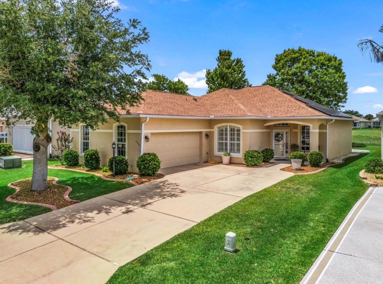 Experience the best of Florida living in this nicely updated Golf Course Front home perfectly positioned on the 8th Fairway with beautiful curb appeal. Located in STONECREST, a 55+ gated community just a short golf cart ride to The Villages! This residence offers effortless access to dining, shopping, entertainment, and recreation while maintaining the privacy and tranquility of an exclusive golf course setting. This Kingsley Model was designed for both entertaining and everyday comfort and has been recently updated with luxury laminate flooring 2026, Epoxy-coated Garage Floor and Paint 2026, ROOF 2022, SOLAR EDGE HOME Solar System 2022 for energy efficiency, Florida Room, Stainless Steel Appliances, Corian Solid Surface Counters, Elegant Crown Molding and much more! Upon entering you'll be impressed with the spacious open concept design, abundance of natural light, 10ft soaring ceilings with sweeping golf course views. The Florida room provides a seamless extension of additional living space creating the perfect setting to enjoy your morning coffee, sunset cocktails or year around entertaining.  The oversized Primary Bedroom suite features a expansive walk-in closet and spa-inspired en-suite complete with a luxurious soaking tub, separate walk-in tiled shower, and a private water closet. The split 2 bedroom design and 3rd bonus room/bedroom/den with closet located in hall make your guests feel at home with their private bath. Stonecrest is a 55 + community with a all the amenities, tennis, pickleball, softball, 3 outdoor swimming pools, one indoor pool, fitness center, 90 different groups and clubs, 18 hole championship golf course, Broad Stripes Restaurant and Social Club, and gated community with a higher level of security with NO BONDS, NO ANNUAL FEES and LOW monthly association fee of only $152!