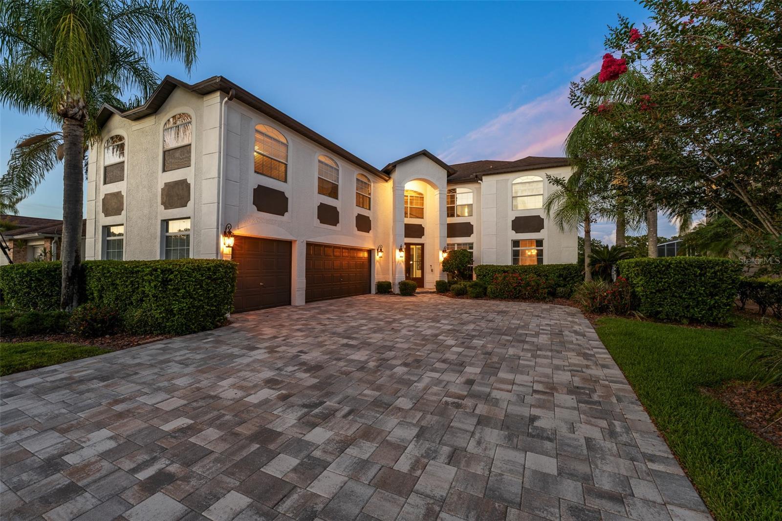 Introducing this exceptional 5-bedroom, 2.5-bath, 3-car garage, pool estate located on the golf course in the highly sought-after Windsor Park neighborhood of the gated, Eagles Golf Course Community. A grand entrance welcomes you through elegant French doors into a soaring foyer highlighted by a stunning chandelier. Crown molding throughout the first floor adds timeless sophistication, while rich wood flooring enhances the home's warmth and character. Designed for both entertaining and everyday living, the formal dining room features a convenient pass-through to the one-of-a-kind kitchen. The beautifully updated kitchen features quartz countertops, large center island, gas range, stainless steel appliances, large tile backsplash, wine refrigerator, double closet pantries, dry bar, and a breakfast nook overlooking the pool area. The spacious family room showcases a wood-burning fireplace with mantle surrounded by pocketing sliding glass doors that open to the screened lanai and pool, where breathtaking pond and golf course views create the perfect backdrop. The pool area is fully screened in, provides ample open and covered seating areas, and is tastefully outfitted with travertine. A versatile formal living room on the first floor offers flexibility as a home office, den, or additional gathering space. Upstairs, the impressive primary suite features French doors, vaulted ceilings, and a cozy reading nook. The luxurious primary bath includes separate his-and-her vanities with LED anti-fog mirrors, a deep soaking tub, and a walk-in glass-enclosed shower. Three additional bedrooms upstairs share a well-appointed bathroom with double vanity and tub/shower combination. A massive bonus loft filled with abundant natural light provides endless possibilities for a game room, media room, or second living area, and includes a wet bar with granite countertops. Completing this outstanding property is an oversized 3-car garage with durable epoxy flooring. Enjoy Florida living at its finest with resort-style outdoor spaces, scenic golf course and pond views, and a prime location within one of Odessa's most desirable gated communities. Conveniently located just minutes from Tampa International Airport, top-rated shopping and dining destinations, parks, nature trails, championship golf, and major commuter routes.