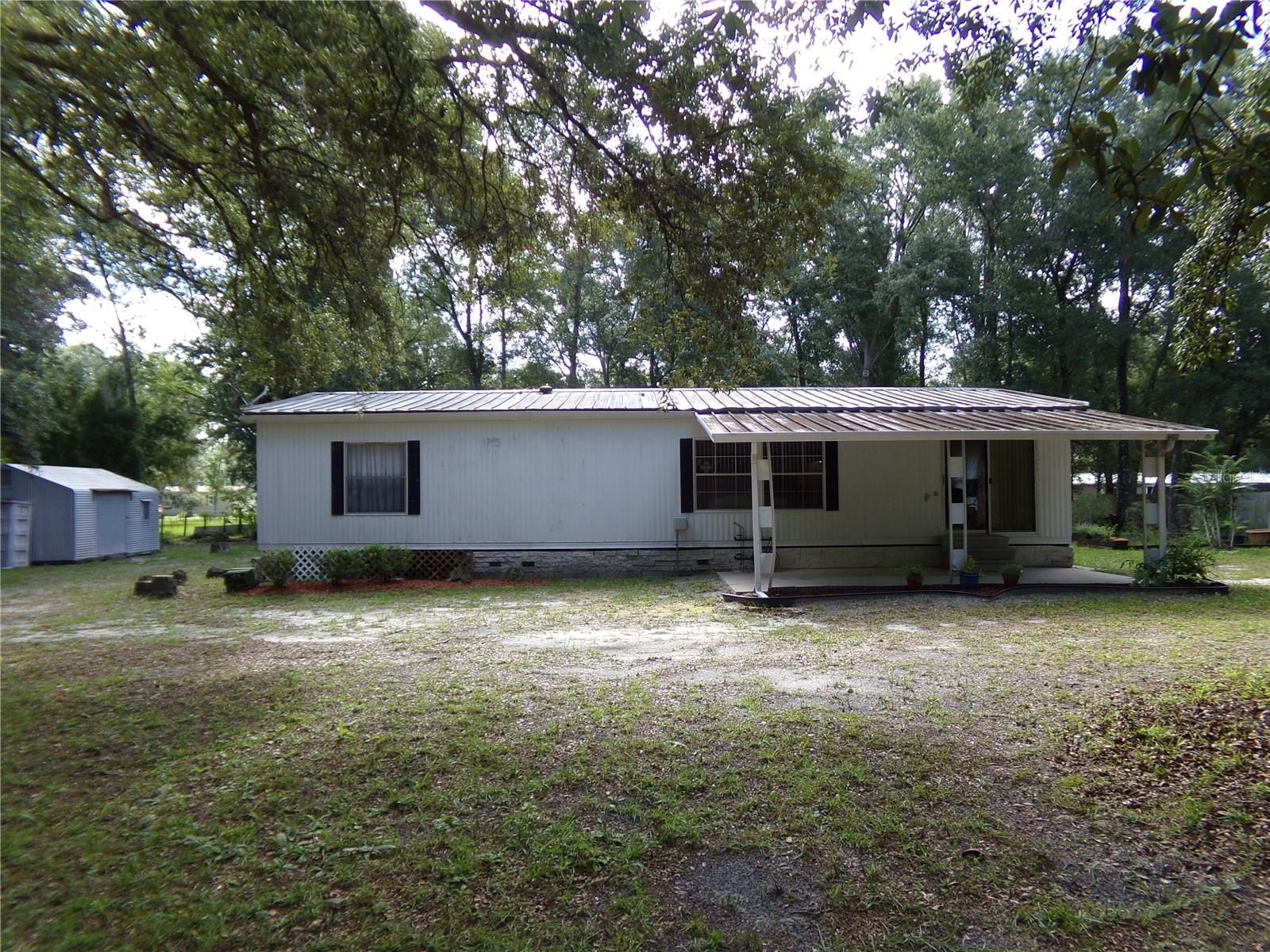Spacious well maintained doublewide mobile home with 2 bedrooms and 2 full bathroom and a Florida room.  The master bedroom has a private bathroom with walk in shower and closet and the second room has a build in dresser for storage.  This well-maintained home is move in ready!  Situated on 2 acres zoned for livestock, at the rear of the house is a screened in porch and a workshop with electric.  This home has had some upgrades to the electrical and plumbing.  A quiet neighborhood just 10 miles to shopping in Bushnell and about 16 miles to I-75 with an easy drive to Wesley Chapel (about 33 miles), Dade City (about 18 miles), Brooksville (about 21 miles).  Conveniently located to hunting management areas (about 11 miles), fishing, parks, trails at the Withlacoochee State Trail (about 11 miles away) , and boating, fishing and camping at Silver Lake (about 15 miles away).