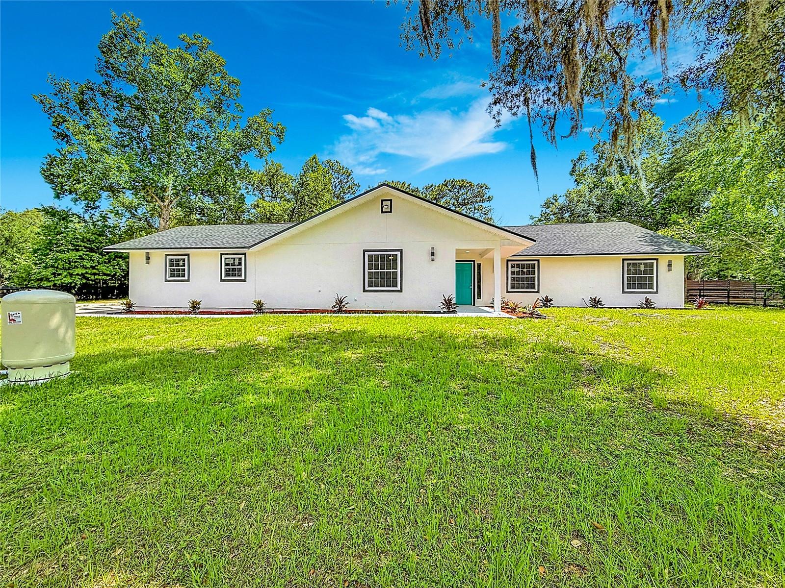 Completely renovated from the studs up, this move-in-ready 4-bedroom, 3-bathroom home sits on 1.03 fully fenced acres. Every major component has been updated and permitted, including the roof, flooring, walls, ceilings, kitchen, and bathrooms. High-end finishes throughout create a modern, comfortable living space, while the expansive lot provides privacy and plenty of room for entertaining, pets, recreational vehicles, or future outdoor improvements. Conveniently located just 20 minutes from Downtown Ocala, this vacant home offers the perfect blend of updated living, usable land, and freedom.