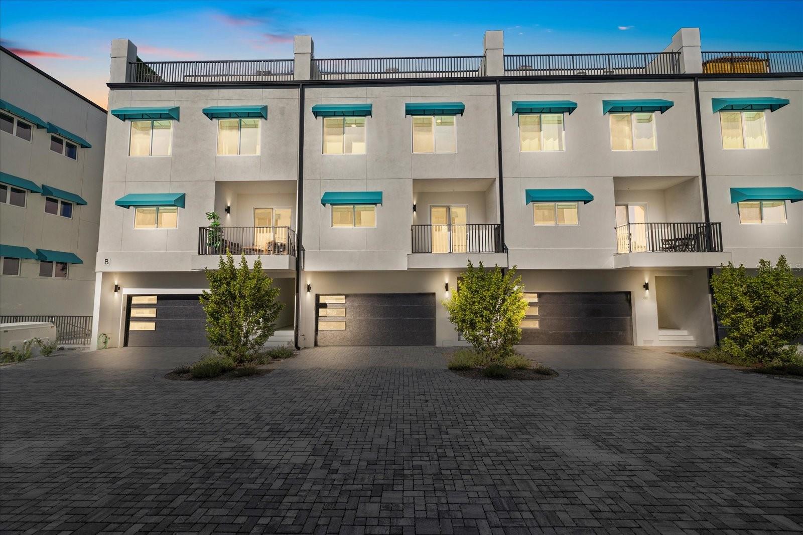 ***Seller Motivated*** Welcome to Azul Townhomes in Madeira Beach. This spacious 5 bedroom, 4 bath residence offers three levels of living plus a large rooftop terrace designed for outdoor entertaining. Located just steps from beach access and the community pool, it serves as an excellent primary home, vacation property, or income producing rental. Approved for short term rentals on a daily, nightly, or weekly basis, it offers strong potential for Airbnb or other rental platforms. Inside, the open layout features high ceilings and abundant natural light. The kitchen includes white shaker cabinetry, quartz countertops, stainless steel appliances, a deep stainless sink, a large center island, and a coastal blue tile backsplash. Luxury vinyl plank flooring extends throughout the main living areas for durability and style. The main living space, guest rooms, and private primary suite are spread across the second and third floors. A balcony off the living area provides a comfortable outdoor extension of the main level. The rooftop terrace offers additional outdoor living space with room for seating, a hot tub, and a future wet bar if desired. The oversized 3 car tandem garage features an epoxy coated floor, excellent storage space, and direct access to the interior stairway and private elevator. This residence combines modern coastal finishes, flexible rental options, and a prime location close to the beach. Schedule your private showing today. - Lets update this listing description to highlight nightly rentals and great for Airbnb as well as seller motivated closer to the top. Also add community pool and the home can also be homesteaded as a primary residence.