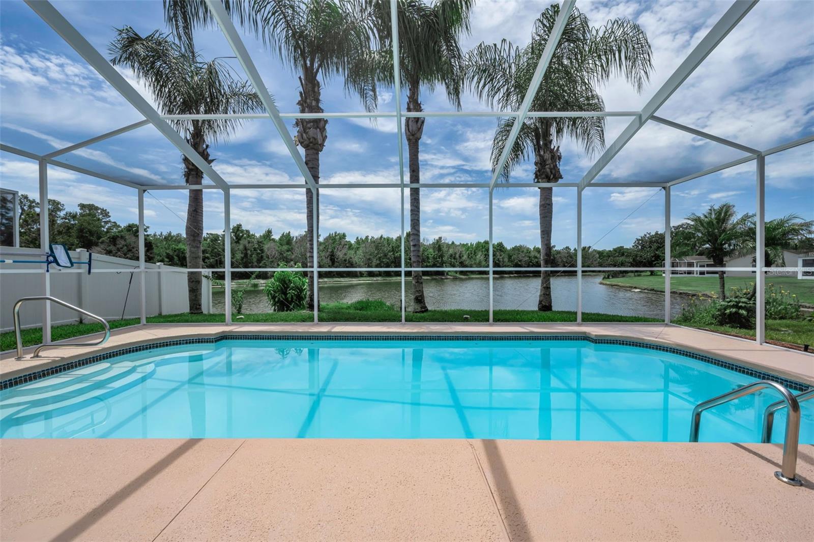Rarely does a home combine breathtaking water and preservation views, an exceptional pool, extensive updates, and true move-in-ready condition in one of Wesley Chapel's most established communities. This meticulously maintained 4-bedroom, 2.5-bath home offers 1,963 square feet of turnkey living on a quiet interior street in Northwood. The private backyard retreat features a beautiful fiberglass pool, recently painted pool deck, new lanai screens, and no rear neighbors, creating the perfect setting for relaxing or entertaining. The updated open kitchen features quartz countertops, soft-close cabinetry, stainless steel appliances, recessed lighting, and a picturesque breakfast nook overlooking the pool and tranquil water views. The spacious primary suite includes an en suite bath and a large walk-in closet, offering a private retreat. The additional three bedrooms are nicely sized and enjoy beautiful water and conservation views. Recent improvements include complete interior and exterior painting, updated bathrooms, an epoxy-coated garage floor, new sprinkler controller and heads, a 2023 water heater, 2018 HVAC with transferable warranty, and a 2015 roof. Northwood is known for its mature landscaping, scenic ponds, community amenities, and low HOA fees. Conveniently located near I-75, I-275, The Shops at Wiregrass, Tampa Premium Outlets, AdventHealth Wesley Chapel, and a wide variety of dining and entertainment options. Exceptional views, extensive updates, and true move-in-ready condition make this home a rare find.