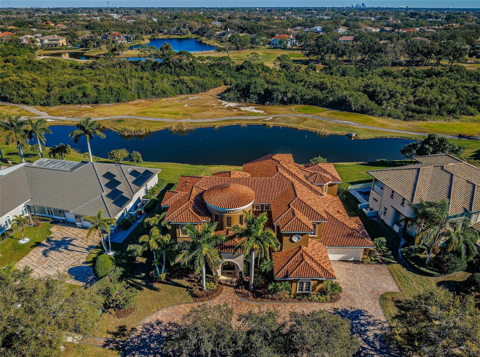 With a staggering level of opulence and luxury - crafted to a degree rarely seen in Tampa Bay, this palatial 10,174 total sqft estate makes a statement like few others.  From its Jerusalem Gold limestone floors and lavish mahogany woodworking, to its Venetian plaster walls and impeccable custom inlaid designer ceilings, everything about this masterpiece sets the standard for high-end elegance.  Built by Windstar, one of the bay area’s premier luxury builders, the most discriminating buyer will recognize an astonishing level of quality and detail craftsmanship built into virtually every element of this home; more than $1M in sublime upgrades were made to this already brilliant residence.  Distinguished cast stone exterior trimwork introduces a magnificent all cast stone entryway arch and arched copper double doors.  Step inside to the majestic 29ft-high foyer with dazzling wrap around flying staircase, and take in endless extravagance and splendor.  The stately sitting room, with towering cast stone gas fireplace, features soaring 24ft-high window views of the pool deck and Bayou Club Golf Course. The executive office, richly adorned in mahogany with numerous custom built-ins, is a CEO-caliber decision-making space.  Plush formal dining is complemented by a sumptuous gourmet chef’s kitchen with extensive custom designer cabinetry, stone counters/backsplash areas, Subzero refrigeration, Wolf gas cooking, a huge island bar/serving center, pass through serving stations, warming draw and much more.  The grand living room, a central gathering and living area, boasts pocketing sliding glass corner doors – creating the ultimate indoor-outdoor living experience.  Step into the luxuriant full-size game room with adjacent theater room.  Game room enjoys a resplendent drybar with full size Subzero beverage chiller and pocketing sliding glass doors that open to the pool deck and outdoor kitchen.  Not to be outdone, the superb theater room seats 10 in ultra-rich comfort.  Upstairs, discover an extraordinary owner’s suite with ornate hallway entry, impressive custom built-ins, morning bar, grand sitting area and a massive, private 42ft-wide 600sqft covered balcony with commanding panoramic views of the golf course.  Separate his and her full luxury baths are spacious (each with large walk-in luxe closet systems), are masterfully-finished in marble/stonework, and are joined by a stunning all marble double-sided walk-in glass shower enclosure.  All bedrooms are large and exceptional in their finishes, and all baths are graceful in their appointments.  Step out back to the striking freeform, zero-entry Pebbletec pool/spa and posh pool deck. Splendid 950sqft covered outdoor entertainment deck, offering three distinct dining/seating/lounging areas, supports a fine built-in outdoor kitchen and gas cooking center.  You’ll appreciate the dedicated pool bath, deluxe elevator, tankless hot water heating and long list of custom amenities. With eye-catching arched hallways, cast stone columns, spectacular window treatments, and artisan quality woodworking/built-ins – nothing is left to want in this peerless home.  Impossible to duplicate anywhere near this price.  An uncompromising, definitive luxury golf course estate!
