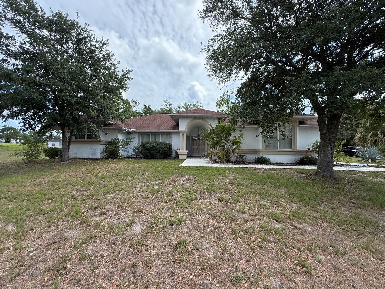 Welcome to this spacious 3-bedroom, 2-bathroom pool home situated on a large corner lot in the heart of Spring Hill. Offering over 2,000 square feet of living space, this home features a versatile floor plan with a living room, family room, and formal dining room, providing plenty of space for entertaining and everyday living. The kitchen overlooks the family room and pool area, creating a comfortable gathering space. Step outside to enjoy the screened pool and expansive yard with room for gardening, pets, or outdoor activities. Conveniently located less than a mile from 4 corners and shopping, dining, parks, medical facilities, and major roadways, this property offers a great opportunity to make it your own while enjoying the Florida lifestyle. No HOA! Permits show and roof permit from 2016 and HVAC permit from 2014.