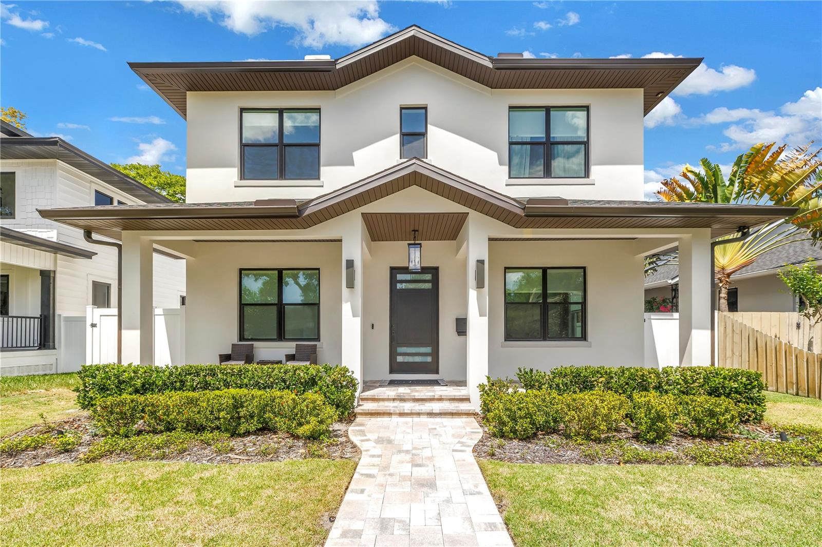 Welcome to this exceptional custom-built residence, completed in 2024 by Devonshire Custom Homes, where thoughtful design meets modern luxury. This stunning 4-bedroom, 3-bath home plus 1-bedroom, 1-bath detached ADU offers superior craftsmanship with all-block construction extending to the roof, and is located in a non-flood, non-evacuation zone, providing durability and peace of mind. Inside, as you enter the expansive entryway, the home features 10' ceilings, wide plank wood floors, a split plan with playroom and office/guest room, and a full guest bathroom. At the heart of the home, an expansive open floor plan with a family room features a remote-controlled gas fireplace, custom built-ins and mantle, and detailed lighting bring warmth and sophistication. The upgraded telescoping sliding doors seamlessly connect indoor living to the expansive lanai—perfect for entertaining with a full outdoor kitchen featuring a gas grill, hood, refrigerator, and wet bar. Step outside to your private oasis featuring a saltwater, heated pool with leathered marble pavers and outdoor lighting to illuminate your front and back yards, ideal for evening gatherings. Back inside, the home features a gorgeous custom kitchen with stainless steel smart appliances, 6 burner duel fuel range, built in refrigerator, Bosch dishwasher, drawer microwave, butler's pantry with wine cooler, and walk in pantry. The in-kitchen dining area overlooks the pool, and a separate mudroom provides a cozy entryway from the garage. You will find elevated finishes throughout, including modern upgraded moldings and baseboards, as well as solid core interior doors for enhanced sound insulation. The home is illuminated by color-adjustable LED can lighting, creating the perfect ambiance in every space. Upstairs, tons of natural light fills the two guest bedrooms with a jack-and-jill bathroom, efficient laundry room with high capacity washer and dryer, and custom built out closets. The luxurious primary suite features a tray ceiling and generous walk in closet, as well as the primary bathroom with dual sink vanity, sensor night lighting, walk in shower, and separate toilet room. The property includes a detached 2-car garage with a beautifully appointed 1-bedroom, 1-bath apartment (ADU), complete with its own separate entrance—perfect for guests, rental income, or multi-generational living. Efficiency and smart living are top priorities, with Hurricane-rated impact windows and custom window treatments, two dual-stage HVAC systems for the main home, smart WiFi-enabled appliances, and a smart garage door opener. Additional upgrades include Borate-treated internal wall studs, a Sentricon termite protection system with transferable warranty, and a whole-house water filtration system. This one-of-a-kind property blends cutting-edge technology, high-end finishes, and functional design—offering a rare opportunity to own a truly turnkey modern home in the heart of Old Northeast, just minutes to downtown St Petersburg, I-275, Tampa and the Gulf Beaches.