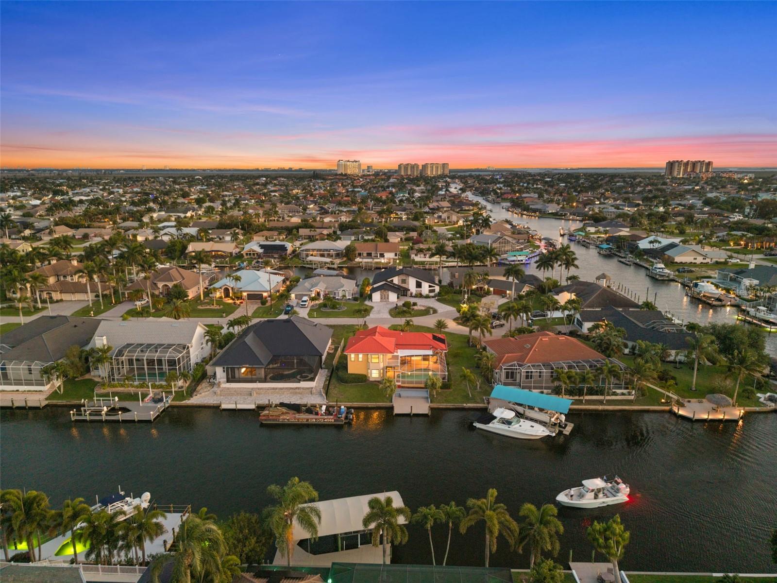 Virtually Staged. JUST A SHORT BOAT RIDE AND NO BRIDGES TO OPEN WATER! DIRECT GULF ACCESS, 2-STORY HOME WITH 2 PRIMARY SUITES, POOL, AND 125-FOOT WIDE CANAL VIEWS! Welcome to 1223 SW 51st St in the sought-after Unit 64 area of SW Cape Coral. This 4-bedroom + den, 3 bath, 2-story waterfront home offers 2,856 square feet, a DIRECT DEEP WATER SAILBOAT ACCESS location, and one of the boating setups serious boaters are looking for. Situated on the Finn Canal, a 125-foot-wide canal off the Gloriana Canal, this home offers NO BRIDGES and NO LOCKS, with quick access out to the Caloosahatchee and on toward the Gulf, beaches, Cape Harbour, Tarpon Point, and more. The cul-de-sac location adds to the appeal, while the wide canal views, mature neighborhood, and established lot give this property a setting that is hard to duplicate. The homeowners also note a major recent investment in the outdoor waterfront living, including lanai pavers, pool tile and surfacing, balcony work, and an expansion-ready dock. Inside, the layout is flexible and spacious, with two separate living areas, a bright open kitchen, indoor and outdoor dining flow, and a den that works well as an office, bonus room, or extra gathering space. One of the standout features is the TWO PRIMARY SUITES, one downstairs and one upstairs, making the home especially appealing for multigenerational living, guests, or buyers who want extra privacy. The upstairs primary suite occupies the second floor and includes its own waterfront sitting area and private balcony, while the downstairs primary suite offers convenient access to the pool area. The guest bedrooms are generously sized, and the guest bath doubles as a pool bath with a large soaking tub. The kitchen and interior finishes were updated with the kind of improvements buyers will notice, including custom soft-close cabinetry, quartz countertops, updated appliances, and tile flooring that fits the Florida boating and pool lifestyle well. Major system and feature updates include a metal roof, 2 complete A/C systems, updated electrical panel, water heater, impact-resistant windows in key areas, custom shutters, new interior and exterior paint, remodeled baths, LVP flooring upstairs and on the stairs, epoxy garage floor, and more. The pool is solar heated and has an above-average size and depth, with an approximately 6-foot deep end. The property is also wired for fiber internet. If boating, poolside living, and a prime Southwest Cape Coral location are on your list, you need to see this home!