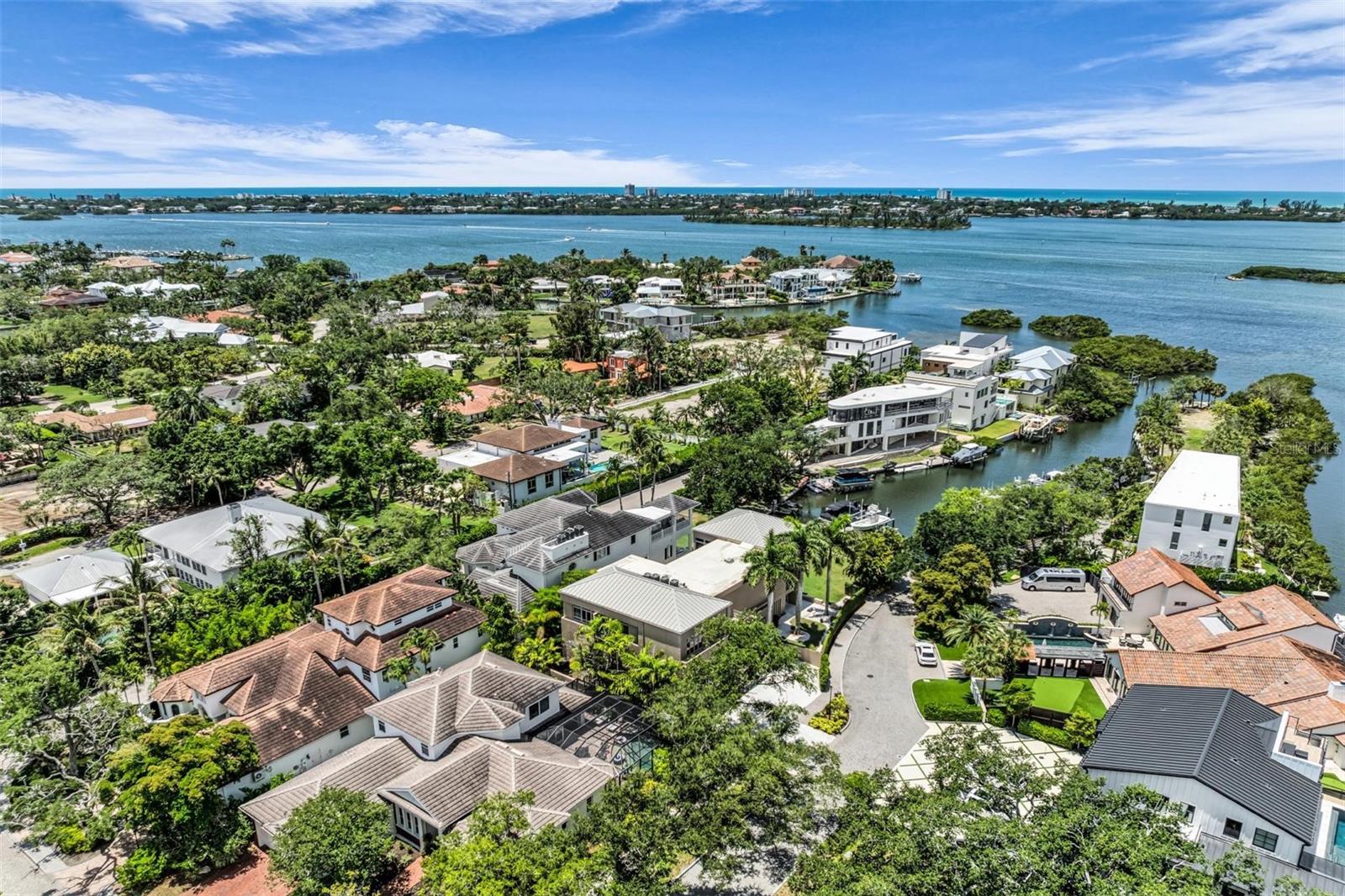Privately positioned in gated Oyster Bay Landings with water views stretching down a short canal to Sarasota Bay, this stunning iconic masterpiece from world-renowned architect Guy Peterson is a breathtaking example of the Sarasota School of Architecture’s style and vision. A comfortable modernistic ambiance flows freely throughout the 5,428 sq. ft. of open living where walls of glass capture spectacular displays of the cerulean blue water and evening skies of fiery beauty. No detail has been overlooked. No expense has been spared. Architecturally striking, this 4-bedroom, 4.5-bath waterfront residence is the ultimate indulgence offering rarity, cachet and grandeur. Dock with 2 lifts is conveniently situated on a waterway unencumbered by any bridge. Floor to ceiling windows frame expansive vistas and abundant natural light complements the thoughtfully-appointed and expertly-planned space. Over 4,000 square feet of outdoor area is inviting and festive, and presents unique vantage points to deliver an exhilarating experience. Expansive terraces promote seamless indoor-outdoor living. Covered entertaining is abundant among the verdant tropical gardens and immaculately manicured grounds. Resort-style amenities including an elevator, courtyard with fire pit and heated pool/spa, and breathtaking reflecting pool with fountain. The stunning kitchen is a culinary delight and complemented by an extravagant amenities package of top-tier appliances, island with seating for 6, 20-ft. long counter for 2 desk workstations, side-by-side but separate refrigerator and freezer, 2 dishwashers, and deep walk-in pantry. The family room is equipped with built-in entertainment wall and opens to a waterfront patio with outdoor cooking center. The great room has travertine floors and cypress ceiling detail, and the office provides a desk with stone countertops and plenty of solid wood cabinetry. A 400-bottle wine room is the highlight of the gaming area with wet bar, electric shades and unique glass chandelier. On the second level are spa-inspired en-suite bedrooms with custom closet systems and elevated ceilings. A 30-ft. bridge leads to the master wing highlighted by incredible water views, sitting room with morning bar, and home gym/office. The primary bath creates an immersive experience with a 16-ft. long dressing hall with a wall of built-ins and mirrors, large walk-in specialty closet, multi-faceted shower, deep soaker Jacuzzi tub, separate bidet and laundry chute. In addition, there are two laundry areas, an elevator from ground level to the 2nd and 3rd floors, Creston music and lighting system, Generac generator, and 4-car garage. In one of Sarasota’s most coveted locations along the waterfront, this home redefines coastal living is just minutes from beaches, golf, fine dining and downtown Sarasota’s beloved arts and cultural offerings. When scheduling your exclusive tour of this amazing MODERN waterfront estate, make sure to allow plenty of time for exploring its incredible features, both inside and out. It must be seen in person to be fully appreciated. Even the most discerning buyer will fall in love!