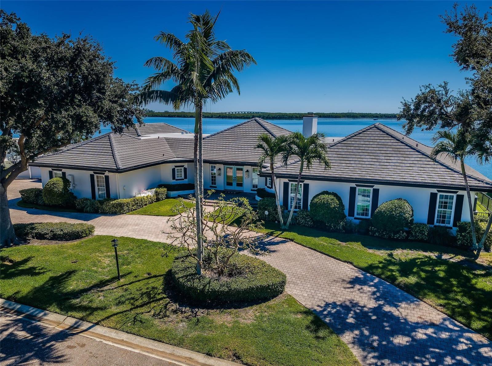 LOCATED ON A QUIET CUL DE SAC IN ONE OF THE FINEST BOATING COMMUNITIES IN FLORIDA, THIS SPACIOUS, SINGLE-LEVEL 4 BEDROOM 5 1/2 BATH LUXURY ESTATE DELIVERS SPECTACULAR WATERVIEWS FROM ITS IMPRESSIVE 164FT OF WATER FRONTAGE! Beautifully landscaped with a grand, sprawling entry, this gorgeously-updated residence enjoys wonderful open spaces and dazzling water views. Elegant columns, striking woodwork and rich driftwood-style porcelain floors complement a resplendent coastal interior layout that conveys the essence of waterfront living. The exceptional open living room with coastal designer fireplace, graceful built-ins and terrific waterviews, transitions to a 46ft-wide 591sqft covered deck with commanding views of the intracoastal waterway. A large, adjacent waterfront family room is the perfect every-day living space for family fun. The dynamic culinary capabilities of this home will inspire the chef in everyone with a sumptuous gourmet kitchen that is truly magnificent - refined stone surfaces/waterfall islands, double islands bars, luxury Thermador/Dacor/Miele appliances, gas cooking, lavish designer cabinetry, extensive food prep areas, and pass-thru to outdoor dining. You’ll love the dedicated butler’s pantry which is exquisite in its finishes, detail and function - with Subzero beverage chiller, Vevor icemaker, Café refrigeration and generous cabinetry. Your waterfront dining experience is supported by a fabulous luxury dry bar with Thermador wine tower, Vevor beverage chiller and matching cabinetry/counters. From your kitchen, step out to a 31ft-wide 365sqft screen-enclosed outdoor dining/lounging deck overlooking the water – an area that will add joy to indoor/outdoor living. All 4 bedrooms are huge and en suite with alluring full baths and attractive walk-in closet systems. The primary suite is water-facing and offers 2 beautiful walk-in closets, and dedicated access to a massive 36ft-wide 438sqft screen-enclosed deck with far-reaching waterviews (ideal for private moments and lounging day/night). The primary bath is plush and features a lovely dual vanity, superbly-finished walk-in glass shower with dual shower heads, and a rare custom built-in sauna. The delightful 2nd bedroom suite overlooks the waterfront and opens to the covered deck. An oversized office provides substantial built-ins and is flexible in purpose (fitness, game, theater, etc.). Out back you’ll discover pristine and seemingly endless views of remarkable blue-green waters. 6,000lb platform lift provides easy access to open water. The stunning Pebbletec pool/spa is private and is surrounded by a posh travertine paver lounging deck. Many value-added features & extras. This is the best commuting waterfront location in Tampa Bay. Close to I275 - reach the beach in 4 min, downtown St. Pete in 10 min, Tampa Airport in 25 min. An outstanding luxury value in a premier location! Buyer to verify dimensions.