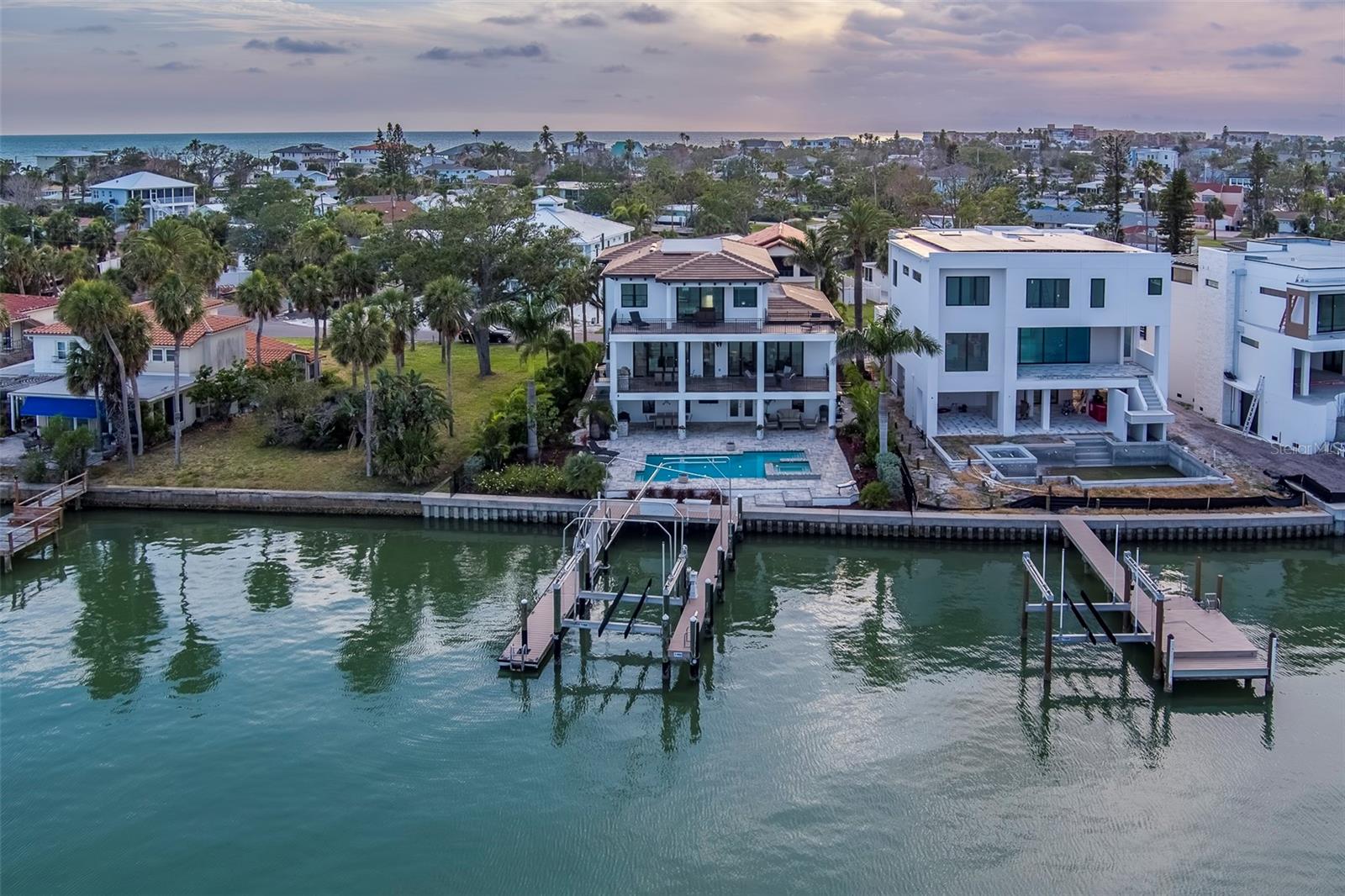 $450K Under Appraised Value – Waterfront Luxury Without the Wait
Offered at $3.25M — recently appraised at $3.7M — this 2021 custom estate delivers $450,000 in instant equity. Why wait 2–3 years to build when you can own a fully completed, move-in-ready waterfront property now?
Featuring a 9,300 sq ft lot, 51’ dock with 20K lb lift, luxury pool, seawall, and high-end outdoor living — this is a rare opportunity to secure value, lifestyle, and immediate enjoyment. Replacement cost today exceeds $3.425M+.
Step into Florida waterfront living without the delays, risks, or design compromises. 

A Modern Waterfront Masterpiece with Every Luxury Imaginable! Welcome to an architectural tour de force—this 2021-built, custom-designed, three-story waterfront estate is a true statement in luxury, design, and craftsmanship. Designed in collaboration with renowned MATTA Architect and constructed with uncompromising quality, this stunning 4-bedroom, 3 full and 2 half-bath residence boasts all-block construction, poured concrete floors and decks, and sleek modern detailing throughout. Step inside and be captivated by soaring ceilings, walls of hurricane-rated glass, and a seamless indoor-outdoor flow that captures breathtaking views of The Intracoastal Waterway. The heart of the home is a gourmet chef’s kitchen with large island and featuring a Thermador refrigerator with separate freezer and wine columns, a Thermador gas range, Sapphire dishwasher, and U-Line ice maker—a dream setup for culinary enthusiasts and entertainers alike. Outdoor living reaches new heights with two full outdoor kitchens with built-in natural gas grills, and an expansive waterfront oasis. Lounge beside the 30’ x 15’ heated and cooled saltwater pool and oversized gas-heated spa, accented by laminar-flow lighted fountains and dramatic natural gas fire features. Water lovers will appreciate 88 feet of massive seawall along with the 52-foot dock with a 20,000-pound boat lift, plus a floating dock perfect for launching all your water toys. Inside, enjoy the comfort and convenience of the largest residential elevator available, a huge 4-car garage with additional room for your motorcycle, bikes, golf cart or other toys! There are lots of built in speakers and the home is wired for sound throughout. Luxury abounds at every turn, from premium finishes and custom millwork to high-end Origin sliding doors opening to expansive terraces overlooking the water. Tucked in a serene neighborhood just steps from the Gulf’s sugar-white sands and close to upscale dining and nightlife, this home truly offers the best of both worlds. No detail was overlooked in this one-of-a-kind builder’s personal residence. If you're looking for coastal luxury at its finest, look no further—this waterfront masterpiece has it all." CHECK OUT THE VIRTUAL TOUR LINKS TO SEE A CUSTOM MUSIC VIDEO AND 3D TOUR FOR THIS SPECTACULAR HOME!