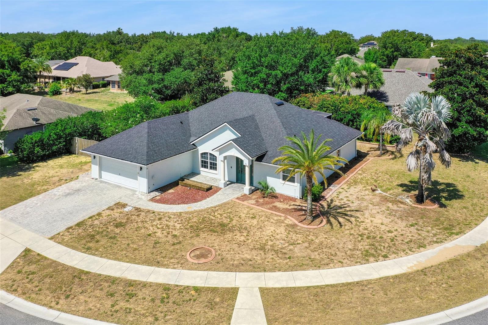 Short Sale. Rare opportunity on an oversized corner lot in the desirable Groves at Baytree community. This 4-bedroom, 2-bath home offers over 2,100 square feet with a NEW ROOF (2025), vaulted ceilings, and an open-concept living, kitchen, and dining layout anchored by decorative columns and an arched window. The kitchen features granite countertops, updated cabinetry, and stainless steel appliances. The split-bedroom floor plan places a spacious primary suite, complete with a bay window, walk-in closet, and en-suite bath with dual sinks, situated privately apart from the secondary bedrooms. Enjoy Florida living on the screened and covered rear porch, all on a low-HOA corner lot with community pool, fitness center, playground, and recreation areas. Conveniently located near shopping, dining, schools, and the waterfront charm of downtown Tavares. Short sale; lender approval required.