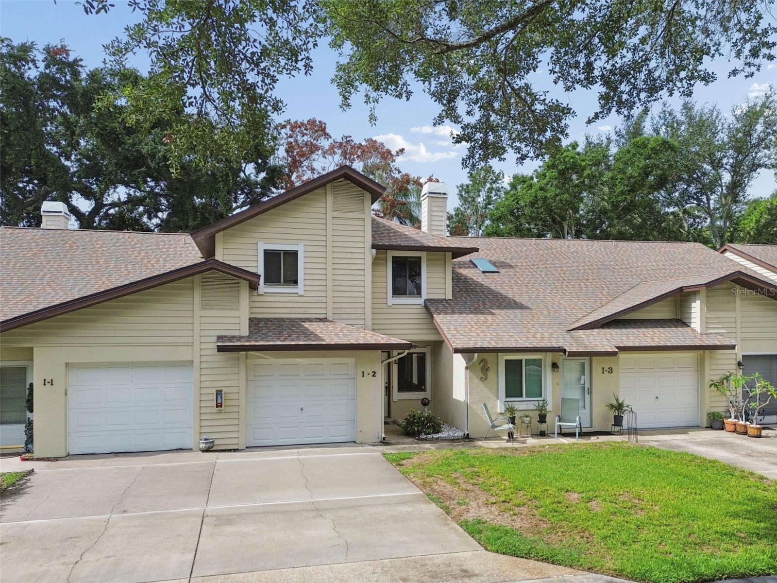 Welcome home to this beautifully maintained 2-bedroom, 2.5-bath townhome nestled in the highly sought-after Green Valley Estates community in the heart of Palm Harbor. Perfectly located directly across from Putnam Park and just minutes from the Palm Harbor Library, Sprouts, Trader Joe's, top-rated restaurants, and everyday conveniences, this home offers an exceptional combination of comfort and location.

Inside, you'll be greeted by soaring cathedral ceilings, natural light from skylights, a stunning stained-glass accent window, and a cozy wood-burning fireplace that creates a warm and inviting living space. The first floor features wood and NEW tile flooring for easy maintenance, while brand-new carpeting adds comfort throughout the upstairs.

The spacious primary suite is designed for relaxation, offering an oversized walk-in closet, an additional closet for extra storage, a dedicated vanity area, and an en-suite bathroom. A screened lanai extends your living space outdoors, providing a peaceful setting to enjoy your morning coffee or evening unwind while overlooking a private backyard with no rear neighbors. Beyond the fence, a tree nursery creates a tranquil, natural backdrop.

Additional features include a one-car garage and a location just steps from the community pool and clubhouse. The low HOA fee provides exceptional value, covering the community pool, clubhouse, water, sewer, trash, pest control, exterior maintenance, and lawn care for truly low-maintenance living. Roof is 2023. Hot water heater is 2024.

Situated within Palm Harbor's highly acclaimed A-rated school district, this home is an outstanding opportunity for anyone looking to enjoy a vibrant community, excellent schools, and one of the area's most desirable locations. Don't miss your chance to make this Palm Harbor gem your own!