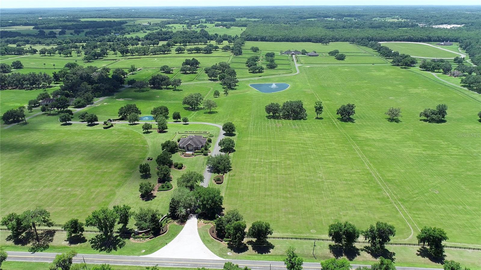 This magnificent property spans 400+/- acres & offers state-of-the-art equine facilities professionally sculpted & architecturally designed for both function & elegance. This estate property is available, for an additional cost, with two simi-contiguous owner’s residence consisting of a 3.3.5 with a 1/1 apartment with 3,988 SF of living area, and a 4/3.5 with 2,428 SF of living area.  Elegant office encompasses 3,984 +/- SF of superior craftsmanship, striking brick façade, & durable asphalt shingle roofing. Inside, you’ll find an elegant lobby/reception area, comfortable lounge/meeting room, & numerous private offices, including an executive CEO office complete with beverage bar & a private ¾ bath. Thoughtfully designed layout features a spacious conference room, copy/fax room, & kitchen/break area, complemented by a welcoming exterior-covered porch. The overall quality of construction is simply outstanding. The property has fiber optic internet cabling, offering modern connectivity amidst nature’s beauty.
This exceptional farm includes a 5,400 +/- SF breeding barn featuring 6 premium stalls, a 13'x13' holding stall, and a dedicated observance/vet/office area. Open lab workspace & wash stall for mares further enhance the breeding experience. West wing of the barn is home to a generous 40’X40’ breeding shed, boasting a concrete floor cushioned with 1” thick rubber matting for the comfort of your equine horses.  Excellent center-aisle quality construction with decorative cupola, copper accents and decorative small cupolas center-aisle.
Adjacent to the breeding barn, stallion barns feature durable concrete block construction with charming brick accents and copper, highlighted by an elegant cupola. Each stable has seven spacious 16’X16’ stalls, wash areas with protective rubber matting, and dedicated tack/feed areas. Double-metal entrance doors boast top-notch hardware and decorative windows, ensuring style and functionality.
The broodmare barn offers 27 stalls, including 24 generously sized 12’X12’ stalls and (3) 12’X17’ foaling stalls. With a 1/2 bath and a 1/1 apartment, this barn combines luxury with essential amenities. 
Experience the luxury of a training barn constructed with concrete block and adorned with elegant brick accents. Facility includes 23 premium stalls, (3) 12’X17’ foaling stalls, 1/2 bath, lab area, feed room, and an inviting 1/1 apartment. European free walker, with an inner covered riding area, & round pen surrounded by meticulously landscaped areas illuminated by uplighting. The general manager's residence boasts approximately 1,884 +/- SF of living space, featuring vaulted ceilings, aluminum sash windows, & stylish decorative lighting throughout. The interior is thoughtfully designed with 4 bedrooms & 2 baths, including an owner's suite with a spacious bathroom. Additional property highlights include covered porches, beautifully landscaped grounds, & a secure gated entrance.  Maintenance shop includes a 20’X30’ office, workshop with a half bath & ample storage alongside 3,617 SF of work area with 2 overhead roll-up doors. A spacious 5,442+/-SF parking area ensures abundant space for all your needs. 3 Bedroom, 3 bath employee home.  Elevated loading docks are conveniently located near the breeding & stallion barns, featuring four efficient loading stations.  All barn roofs have been recently replaced 
Extraordinary horse farm offers a wealth of amenities & unmatched quality that truly must be seen & appreciated.